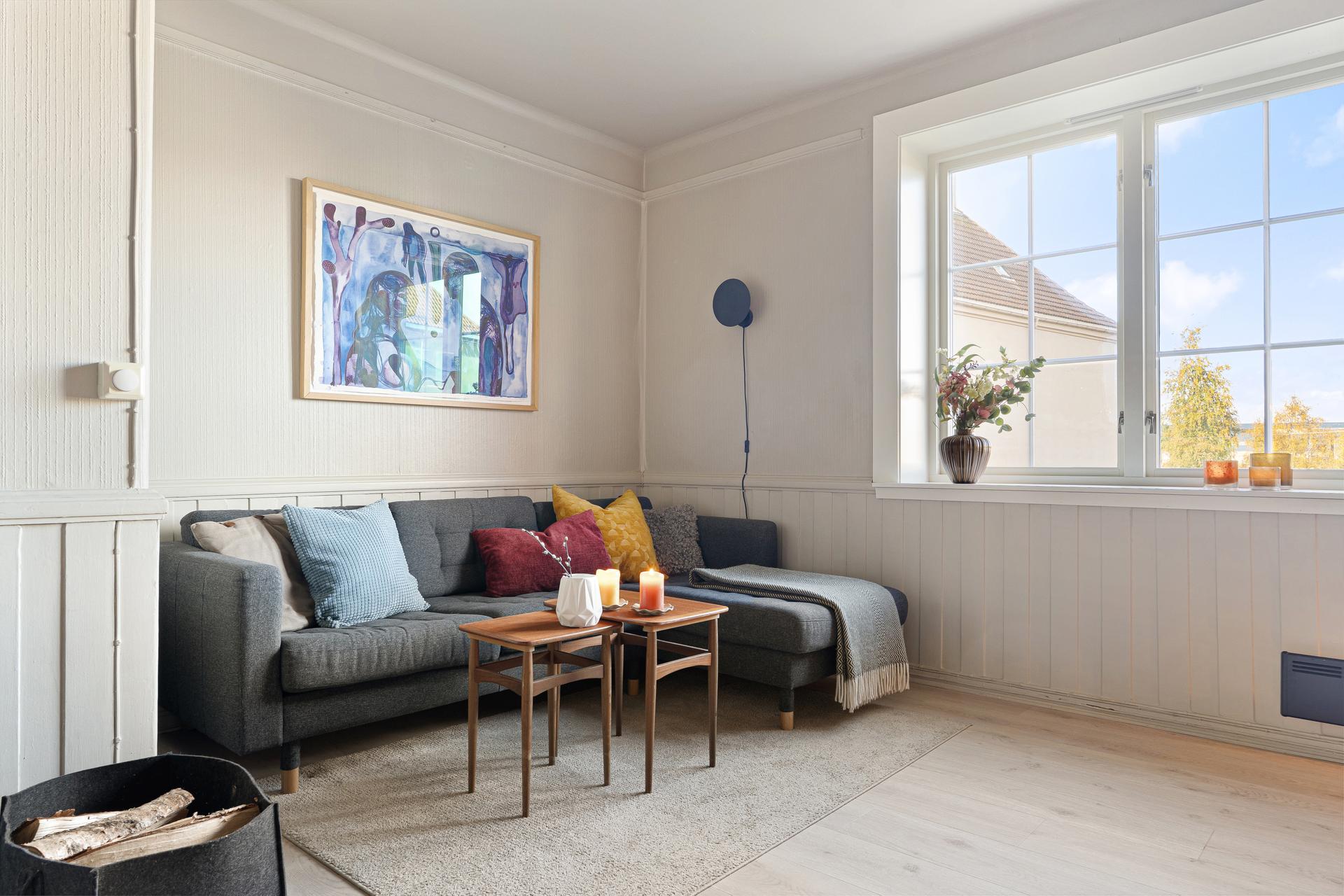 Sofagruppen ligger plassert i hjørnet av oppholdsrommet hvor det får rikelig med naturlig lys fra store vindusflater.. Bilde nummer 3 av 3