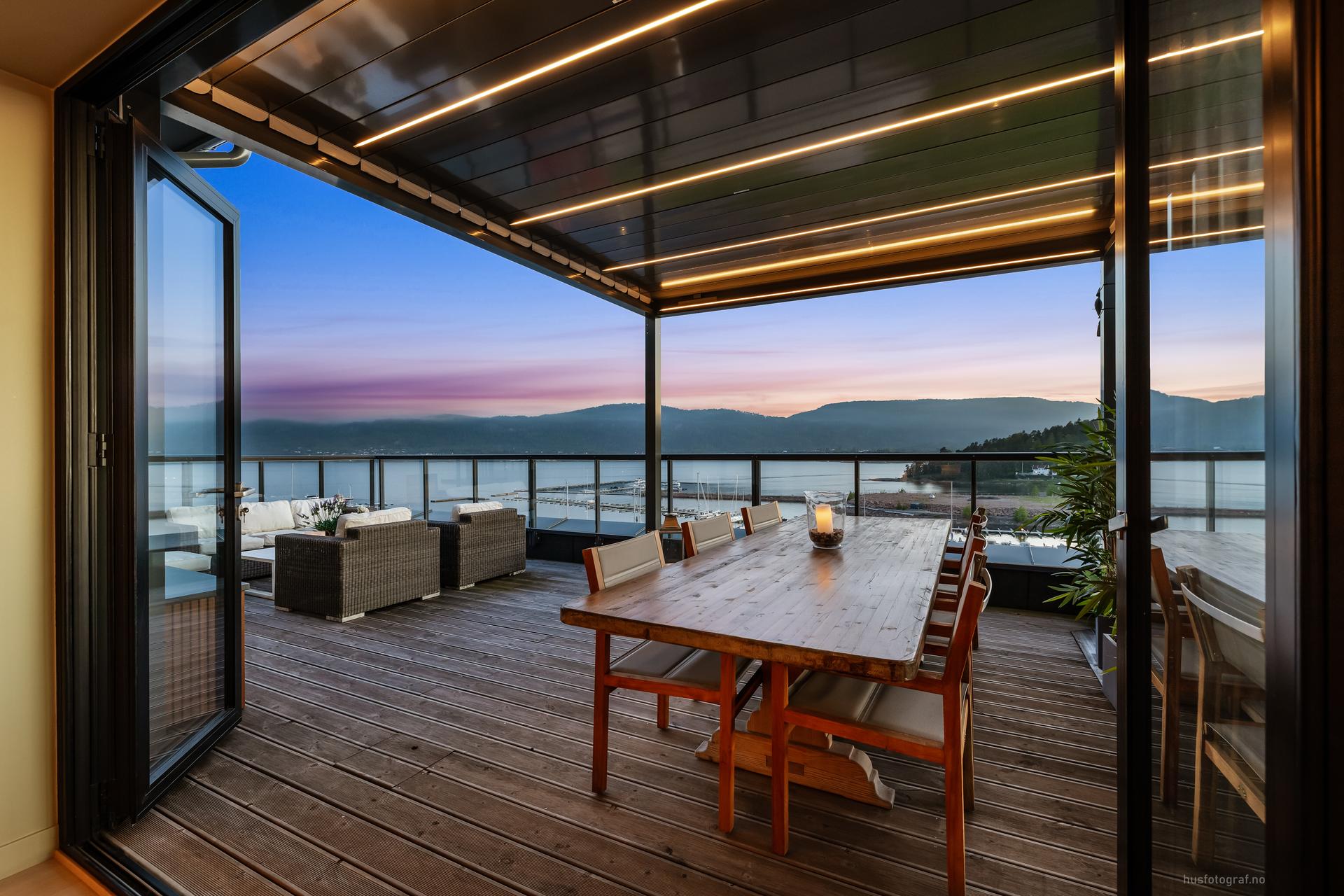 Spektakulær terrasse med panoramautsikt over sjøen og fjellene, perfekt for avslapning og sosiale sammenkomster ved solnedgang.. Bilde nummer 3 av 3