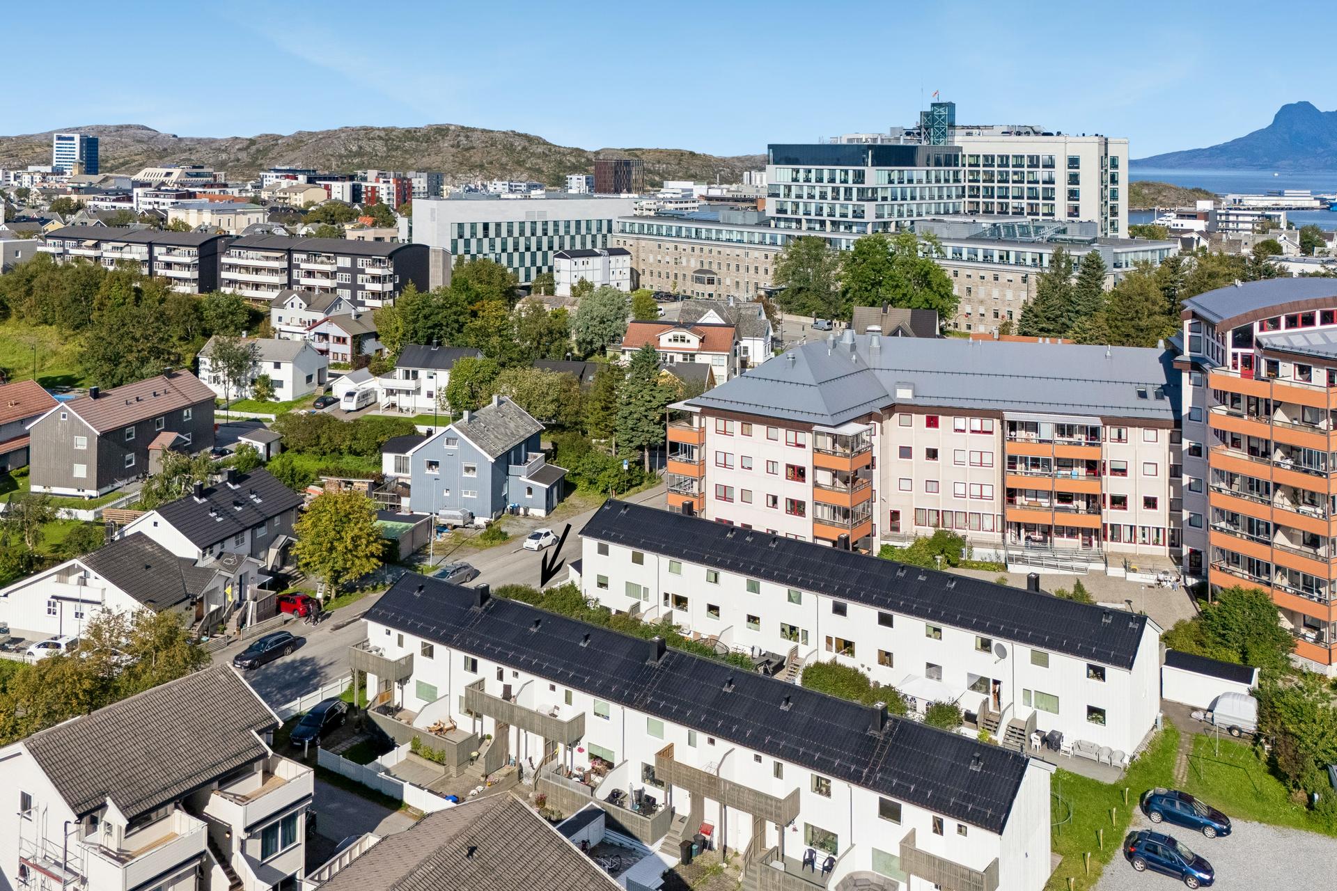Vertikaldelt rekkehus over tre plan med opparbeidet hage og uteplasser på begge sider. . Bilde nummer 2 av 3