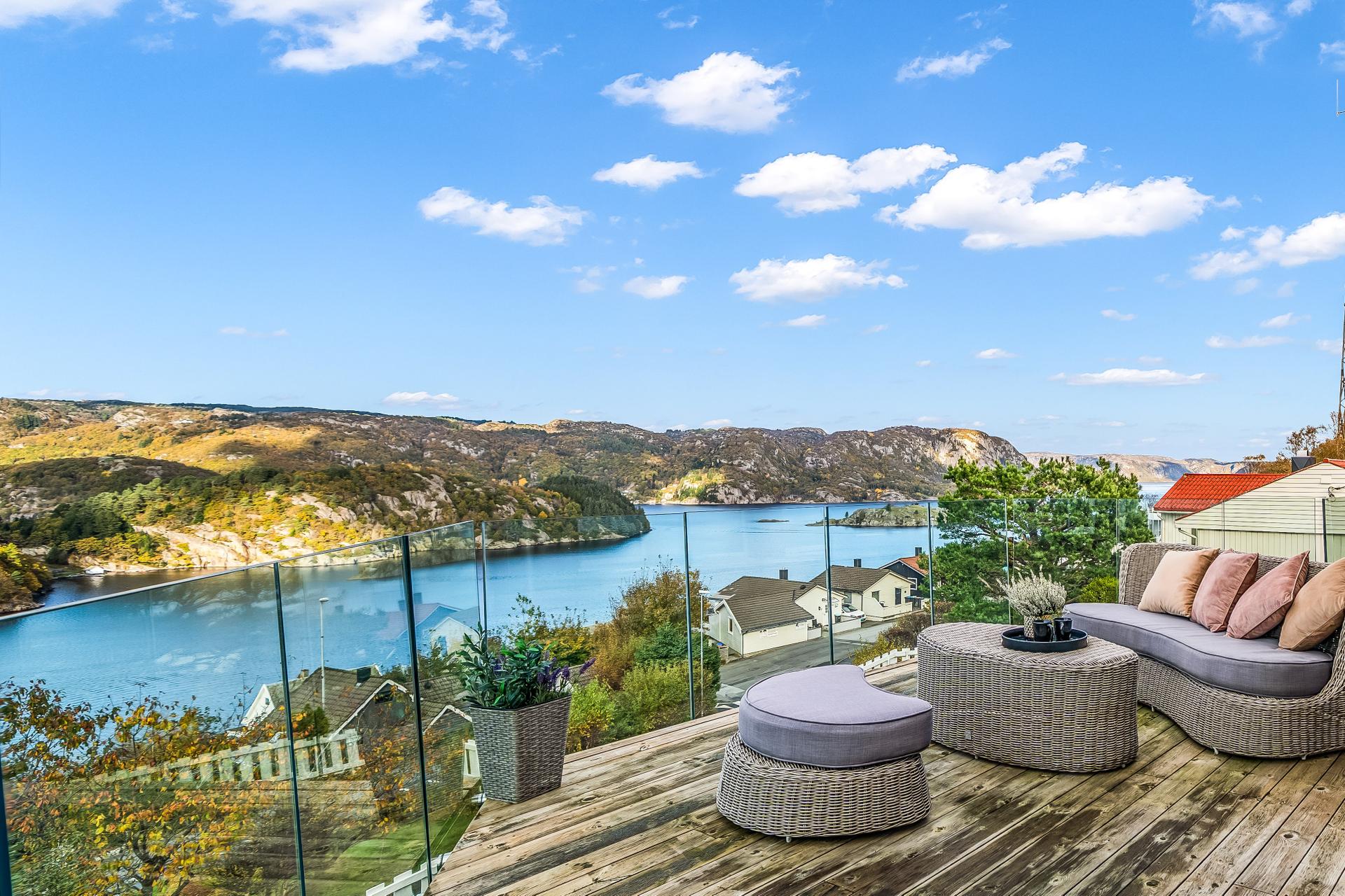 Enebolig over to plan med høytliggende tomt, opphøyd terrasse og utsikt over fjorden.. Bilde nummer 2 av 3