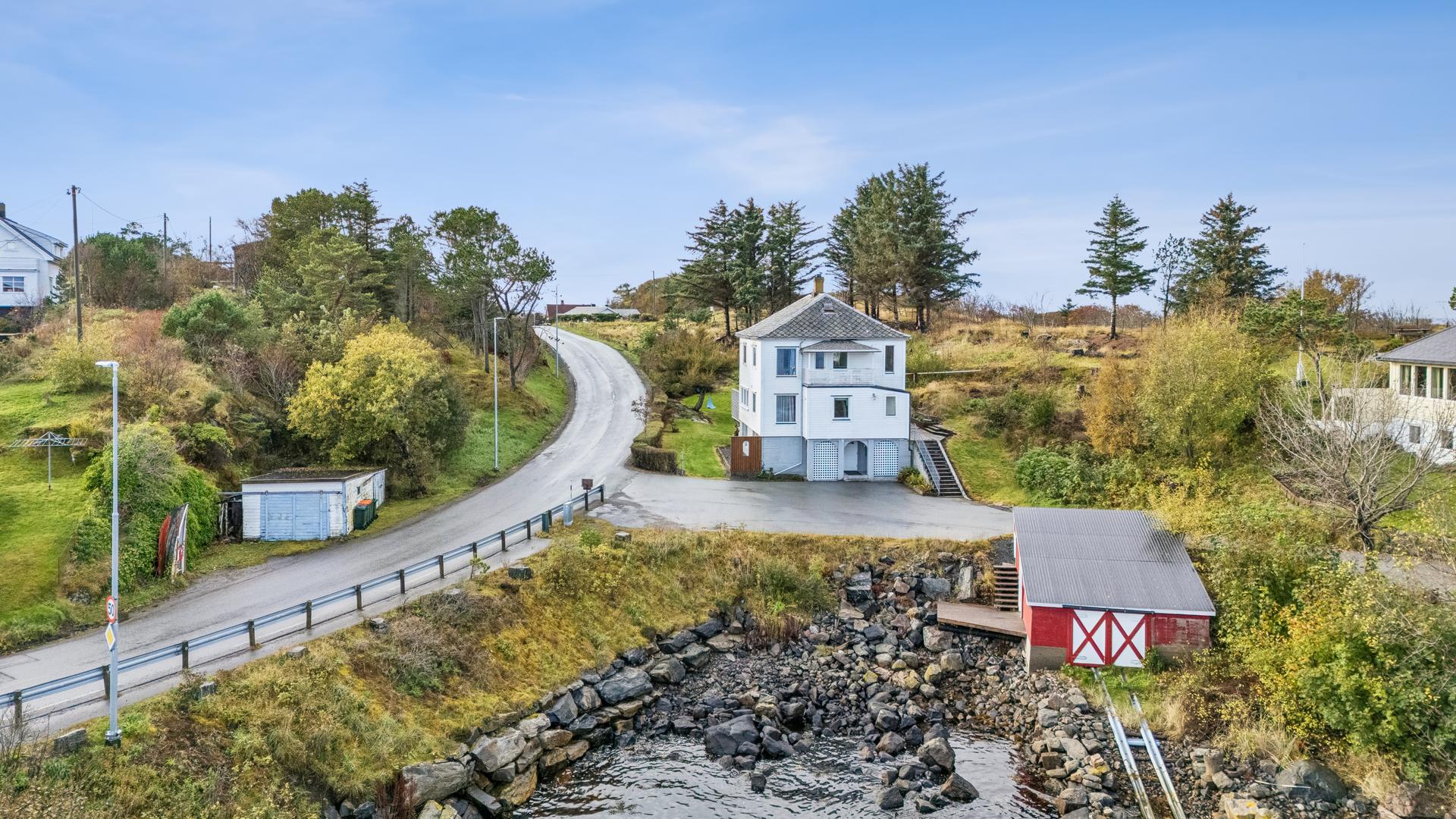 Eneboligen ligger i grønne og naturskjønne omgivelser på Rindarøya.. Bilde nummer 2 av 3