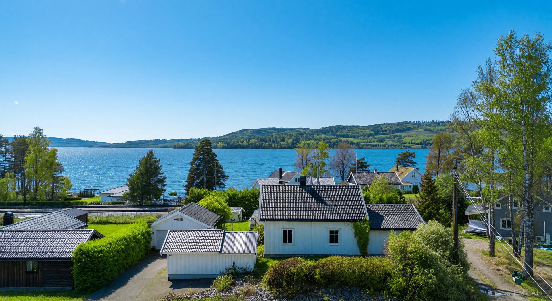 - Sommerbilde deler av tomt, utsikt  og nabolag.  Illustrasjonsbilde (EM1 AI). Bilde nummer 3 av 3