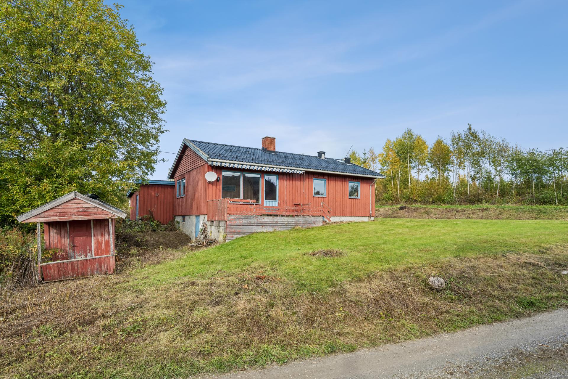 Frittliggende enebolig over et plan og kjeller oppført i 1972, med tilbygget garasje og romslig tomt.. Bilde nummer 2 av 3