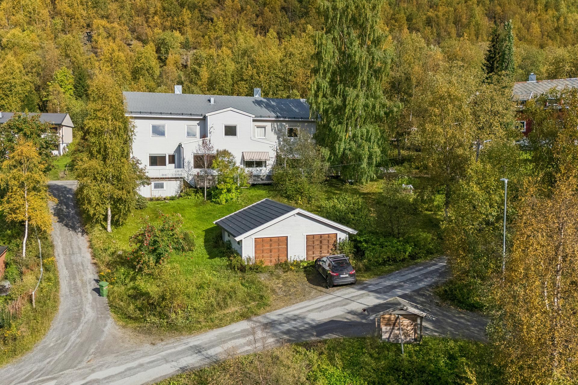 Halvpart av vertikaldelt tomannsbolig over fire plan med tilhørende garasje og stor tomt.. Bilde nummer 2 av 3
