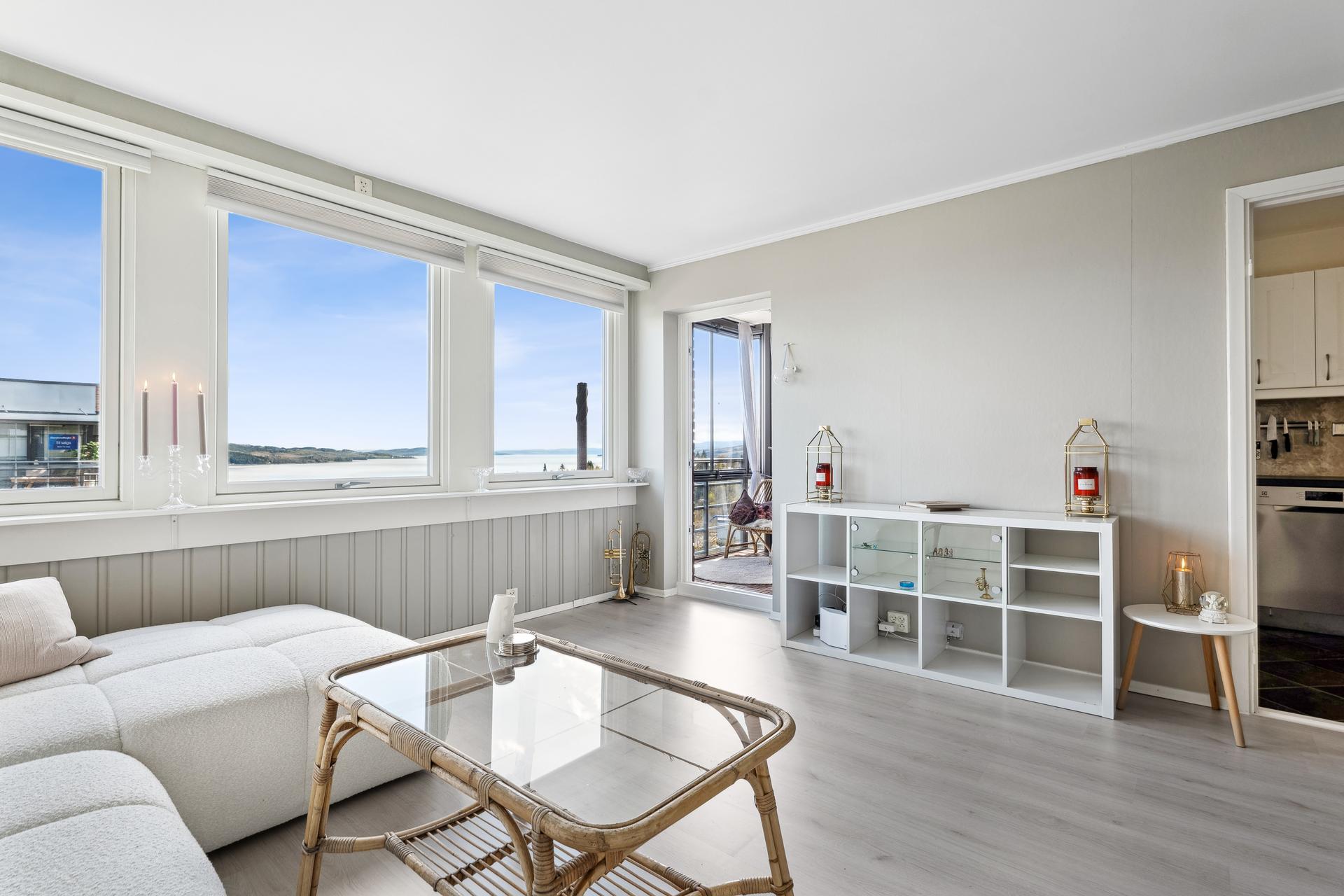 Lys, romslig og lun stue med utgang ut til innglasset balkong. Nydelig Mjøsutsikt. Fotograf: Efkt v/ Kristian Haug. Bilde nummer 1 av 3