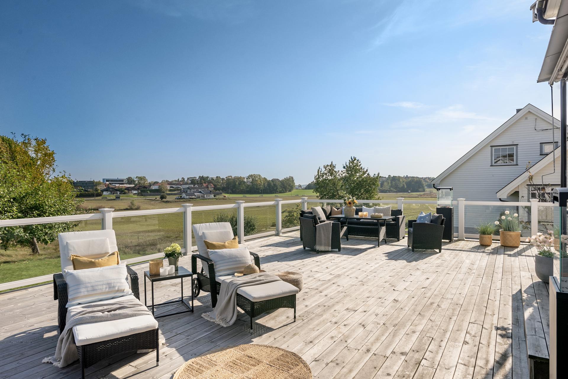 Stor, solrik terrasse med flott utsyn over åpne jorder og fredelige, landlige omgivelser. Bilde nummer 2 av 3