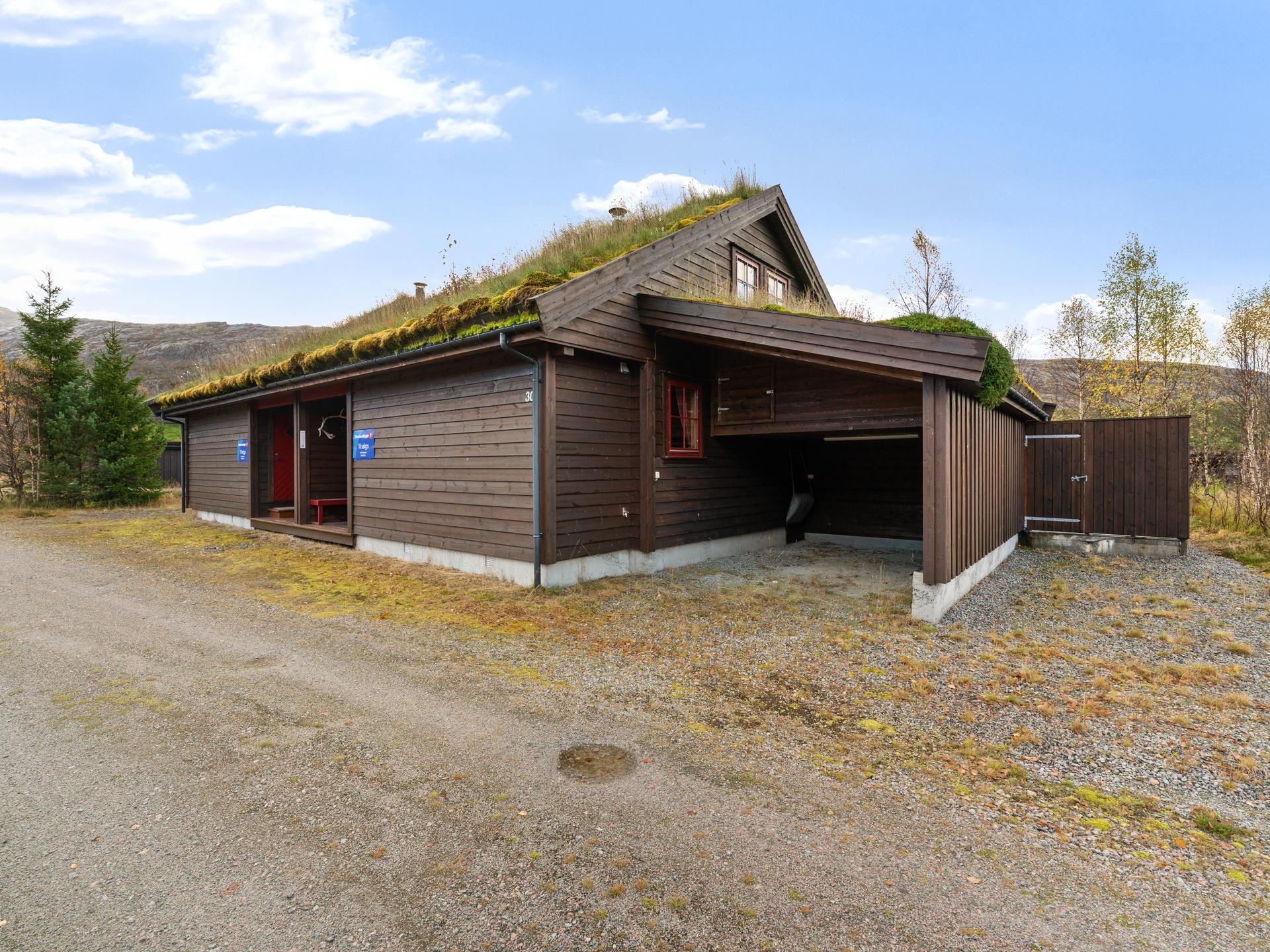 Tilhørende carport gir tørrskodd parkering like ved hyttens inngang.. Bilde nummer 3 av 3