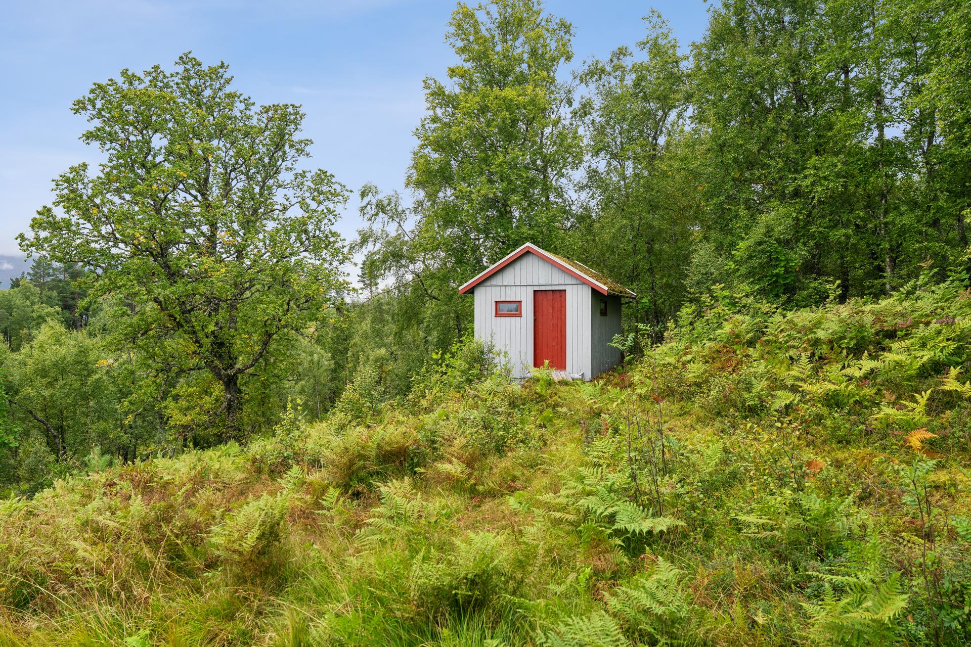 På eiendommen står også et praktisk uthus, innredet med utedo og et eget rom for oppbevaring.. Bilde nummer 3 av 3