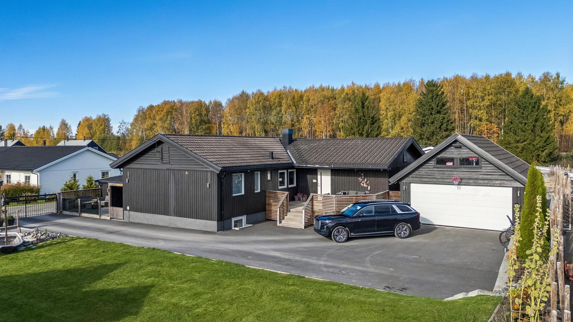 Eiendommen har en tomt på over 1,3 mål med varierte uteplasser, garasjebygg og plenarealer.. Bilde nummer 2 av 3