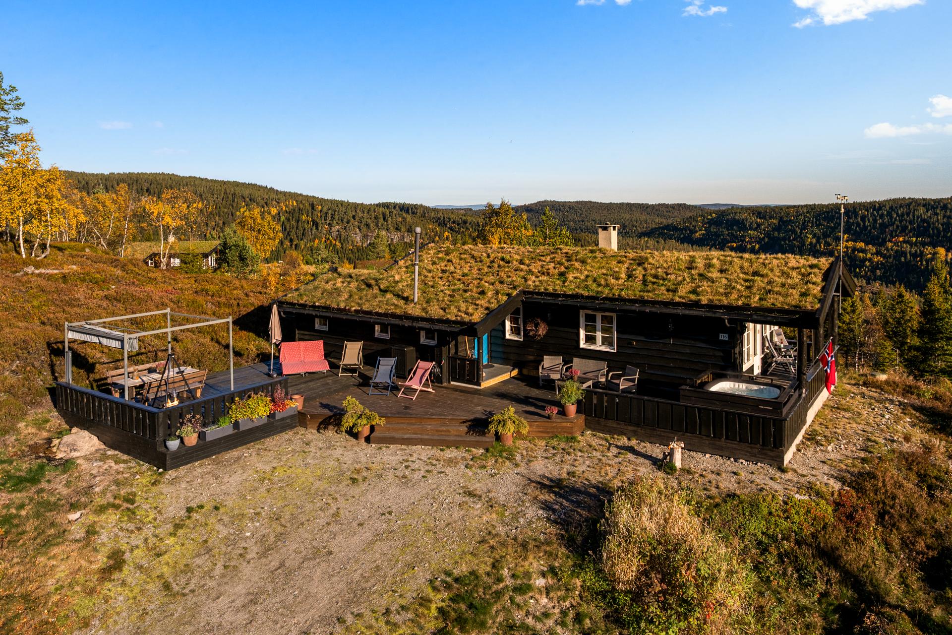 Hytta har villmarkskledning, torvtak og vidstrakt utsikt mot åsene.. Bilde nummer 2 av 3