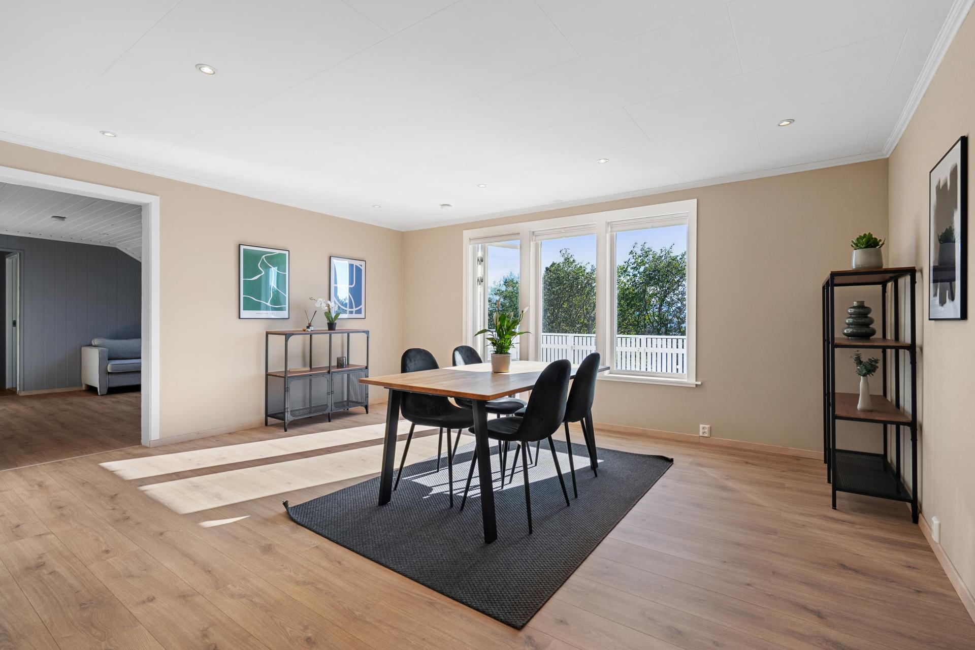 Stuen har god plass til både spisebord og sofagruppe.. Bilde nummer 2 av 3