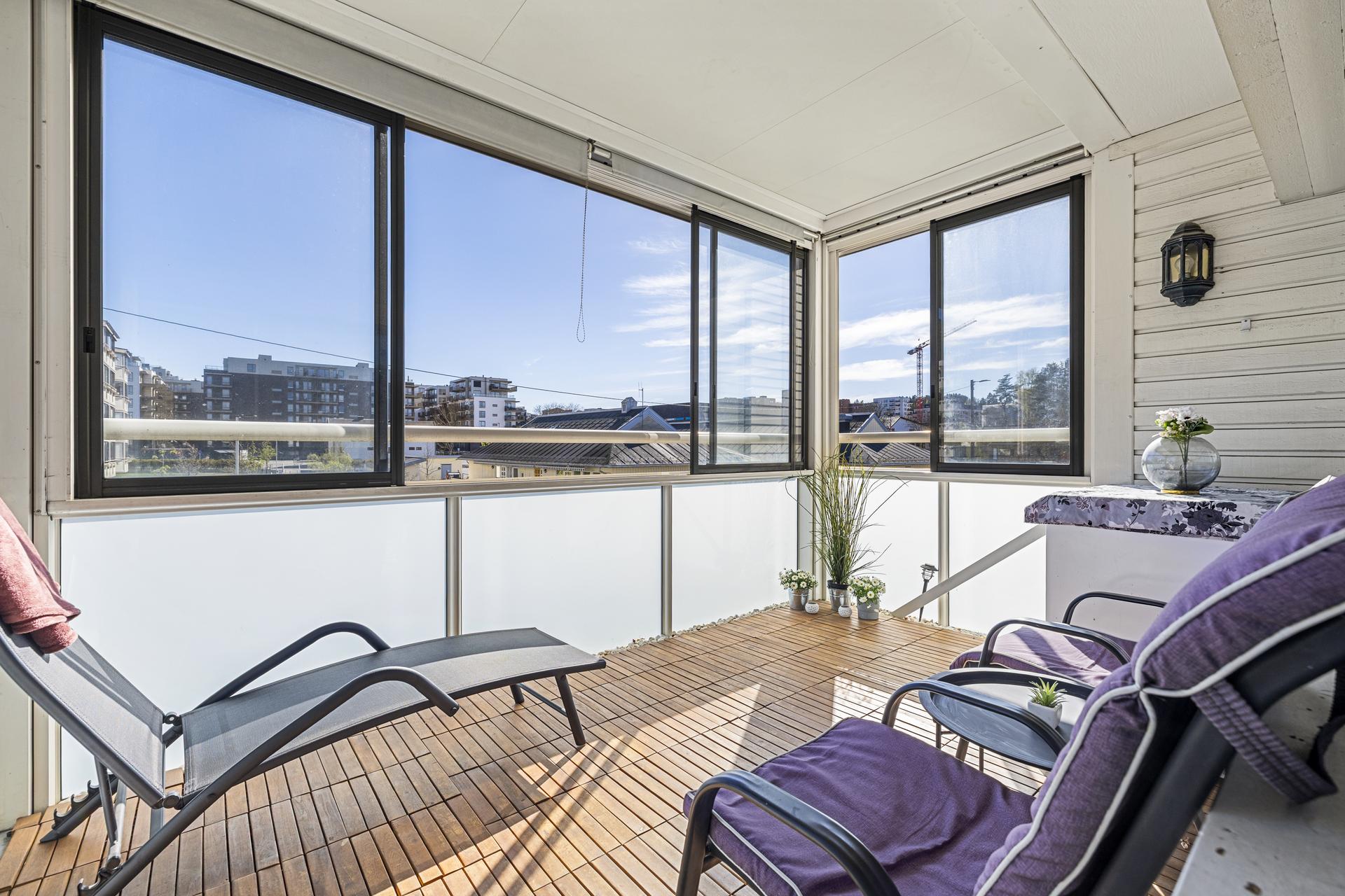  Den innglassede balkongen på 10 m² utvider stuen og fungerer som et lunt oppholdsrom store deler av året.. Bilde nummer 2 av 3