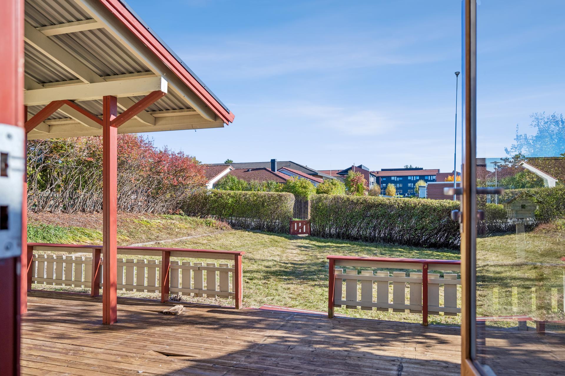 Utsyn fra terrassen mot den usjenerte og grønnkledde hagen. Her har du god boltreplass på terrasse og på grønne arealer. . Bilde nummer 3 av 3