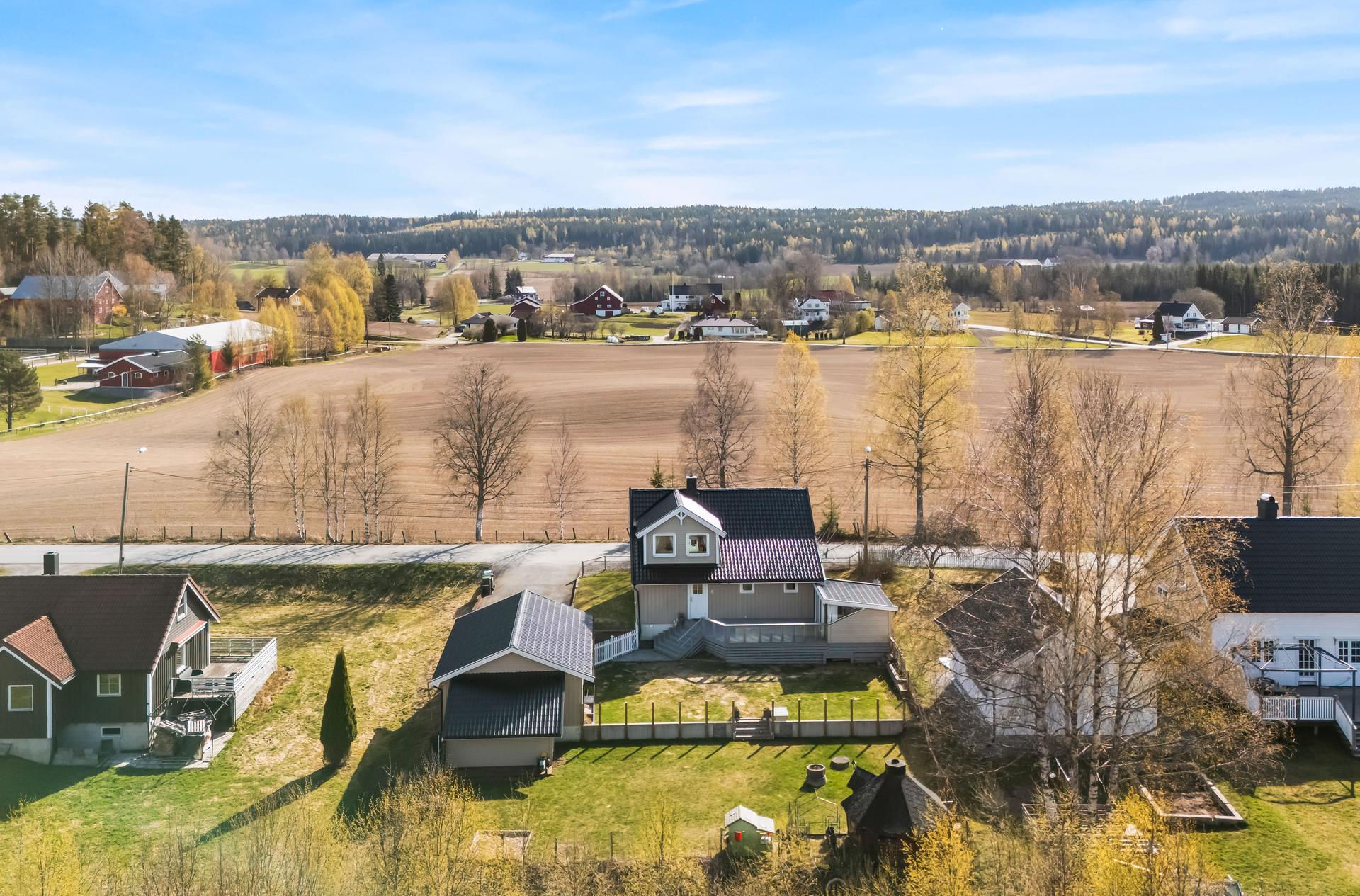 Enebolig med stor, frittstående dobbelgarasje på en flat og opparbeidet tomt.. Bilde nummer 2 av 3