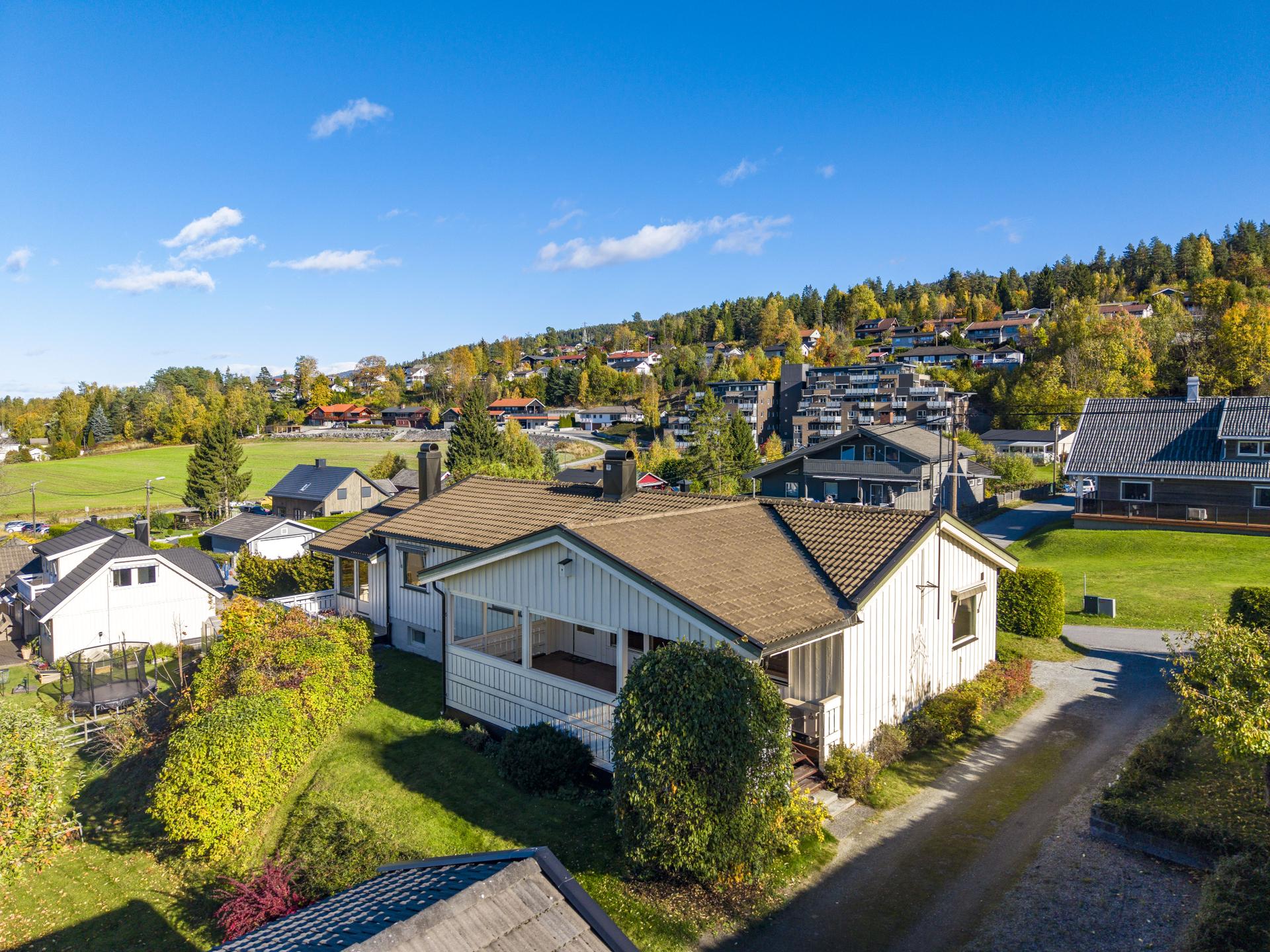 Eneboligen ligger tilbaketrukket i terrenget med terrassen henvendt mot hagen.. Bilde nummer 3 av 3