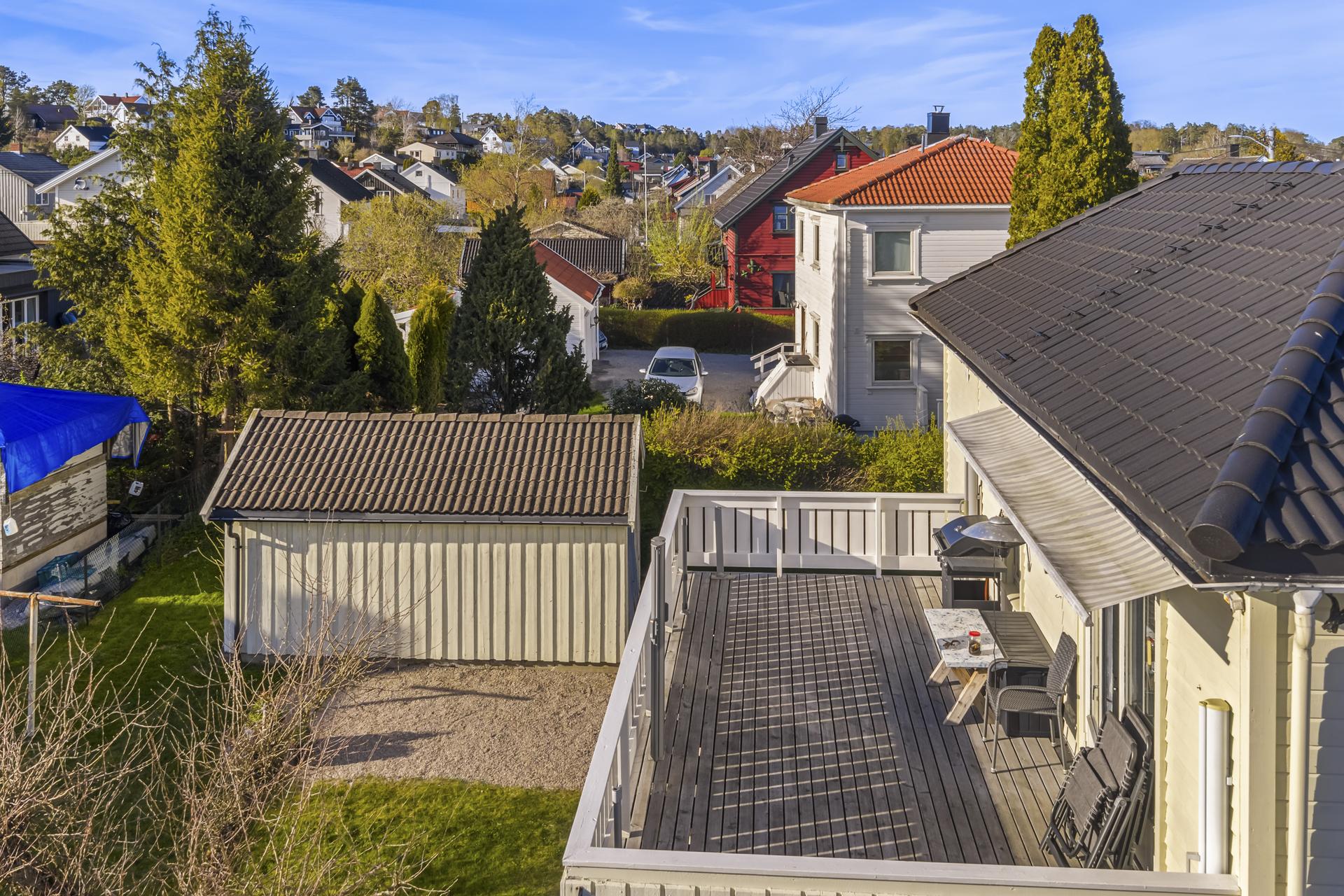 Utsikt fra terrassen i 2. etasje. På tomten står en eldre, frittstående garasje med bod.. Bilde nummer 3 av 3