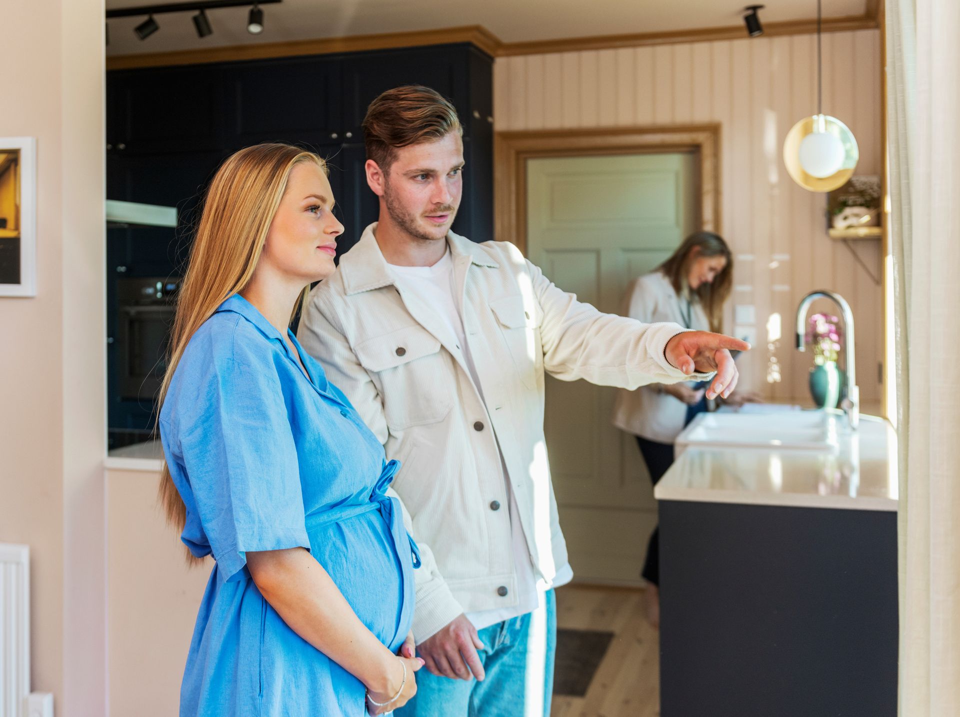 Boligkjøpere på visinng.jpg Ungt par som venter barn er på visning på et kjøkken, peker og diskuterer. Foto