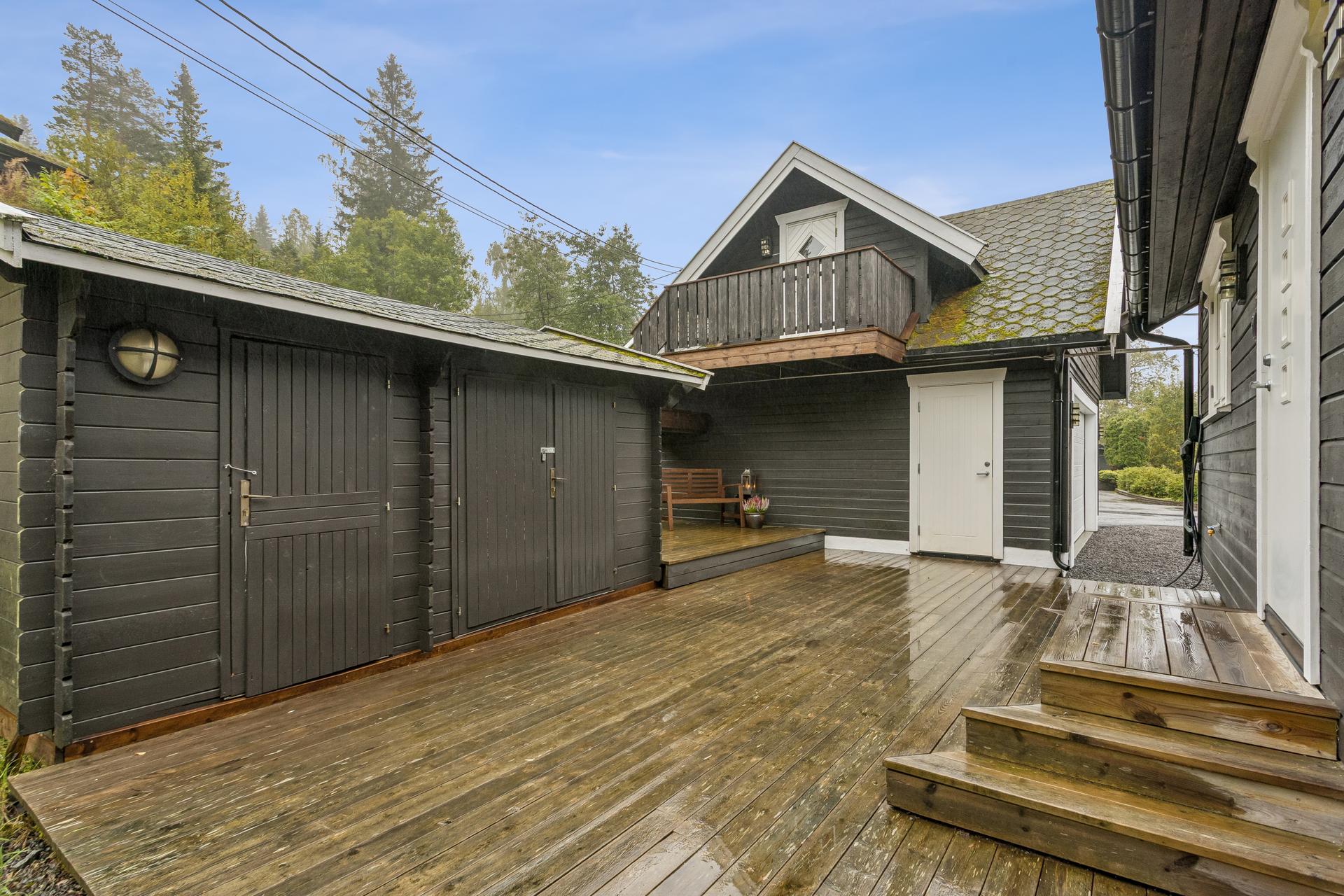Terrasse i treverk etablert med forbindelse mellom boligen, boden og garasjen.. Bilde nummer 3 av 3