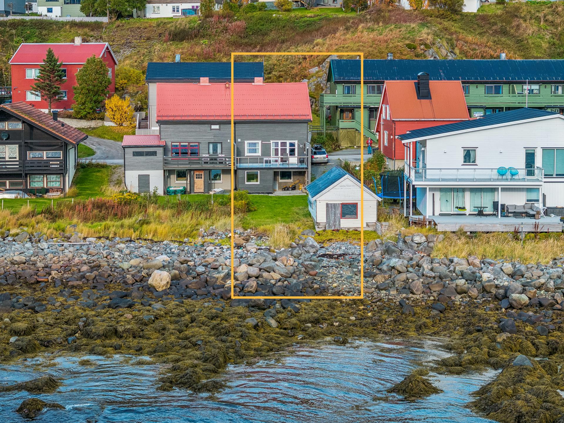 Halvpart av vertikaldelt tomannsbolig over tre plan, plassert i første rekke mot fjorden med eget naust i fjær. Bilde nummer 2 av 3