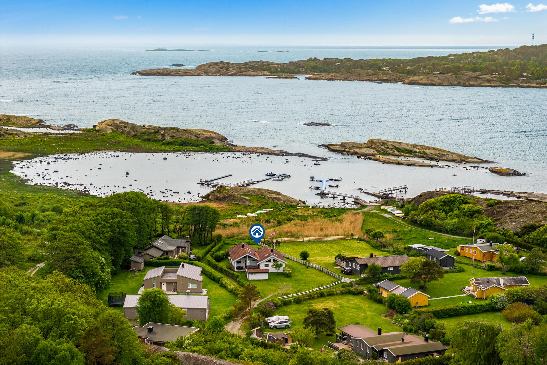 Eiendommen sett fra nord, med den frittstående boden i forgrunnen.. Bilde nummer 2 av 3