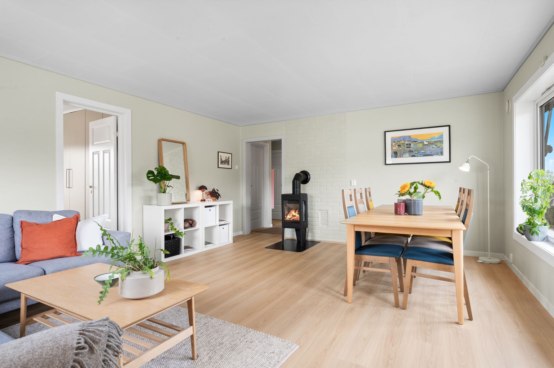 Rommet har flere møbleringsmuligheter, og ved mursteinspipen er det en klassisk vedovn, installert i 2020.. Bilde nummer 3 av 3