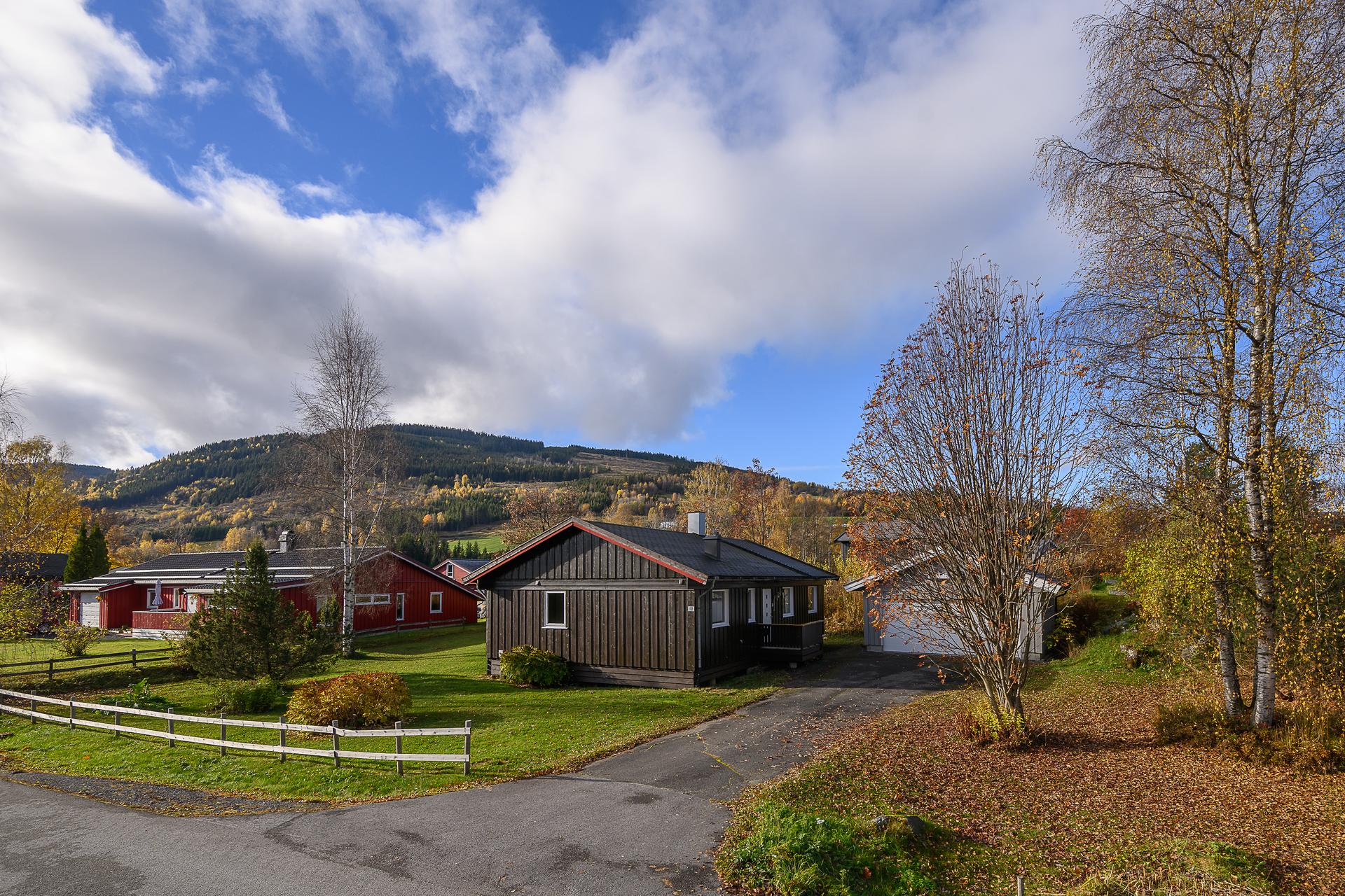 Eiendommen er omkranset av en romslig gressplen med utsyn mot omkringliggende åser.. Bilde nummer 2 av 3