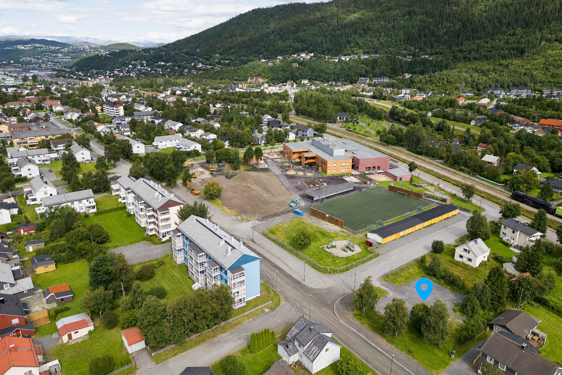 Beliggenheten er suveren for en enkel hverdag med gangavstand til dagligvarebutikker og kun et steinkast fra SFO og barneskolen som ble ferdigstilt i 2026.. Bilde nummer 2 av 3