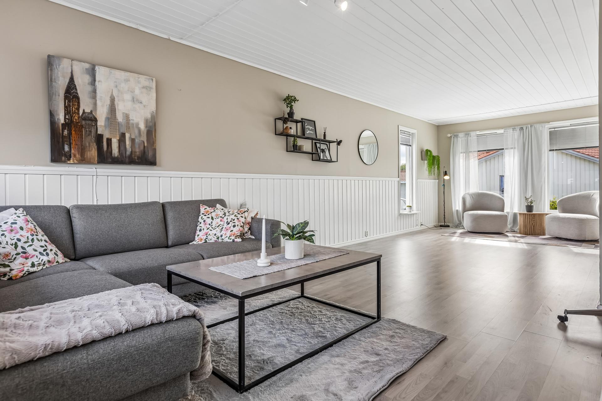 Romslig stue i hovedetasjen med god plass til både sofagruppe og spisebord.. Bilde nummer 2 av 3