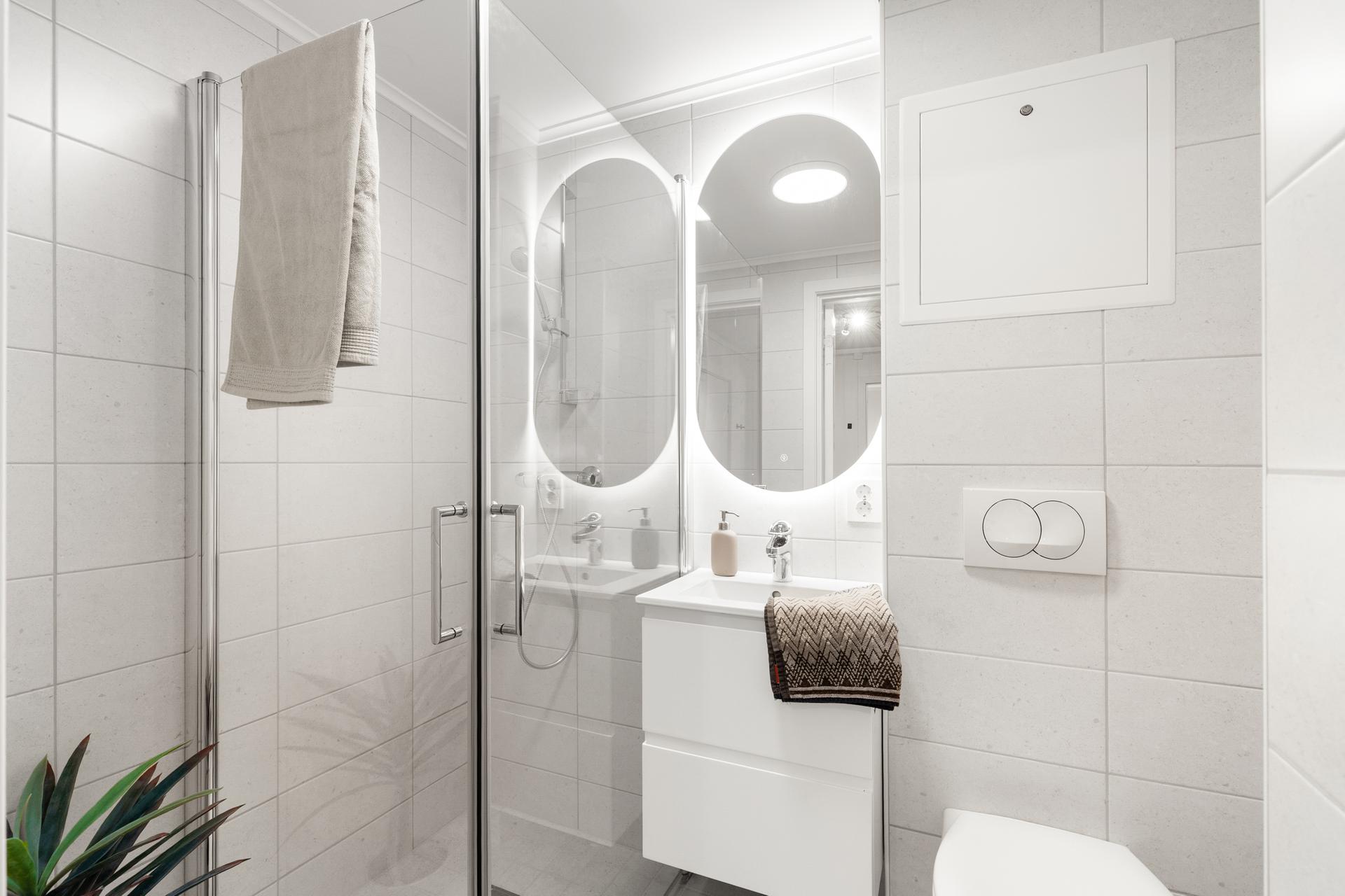 Badet har delikate fliser, gulvvarme, vegghengt toalett og dusjnisje i herdet glass.. Bilde nummer 3 av 3