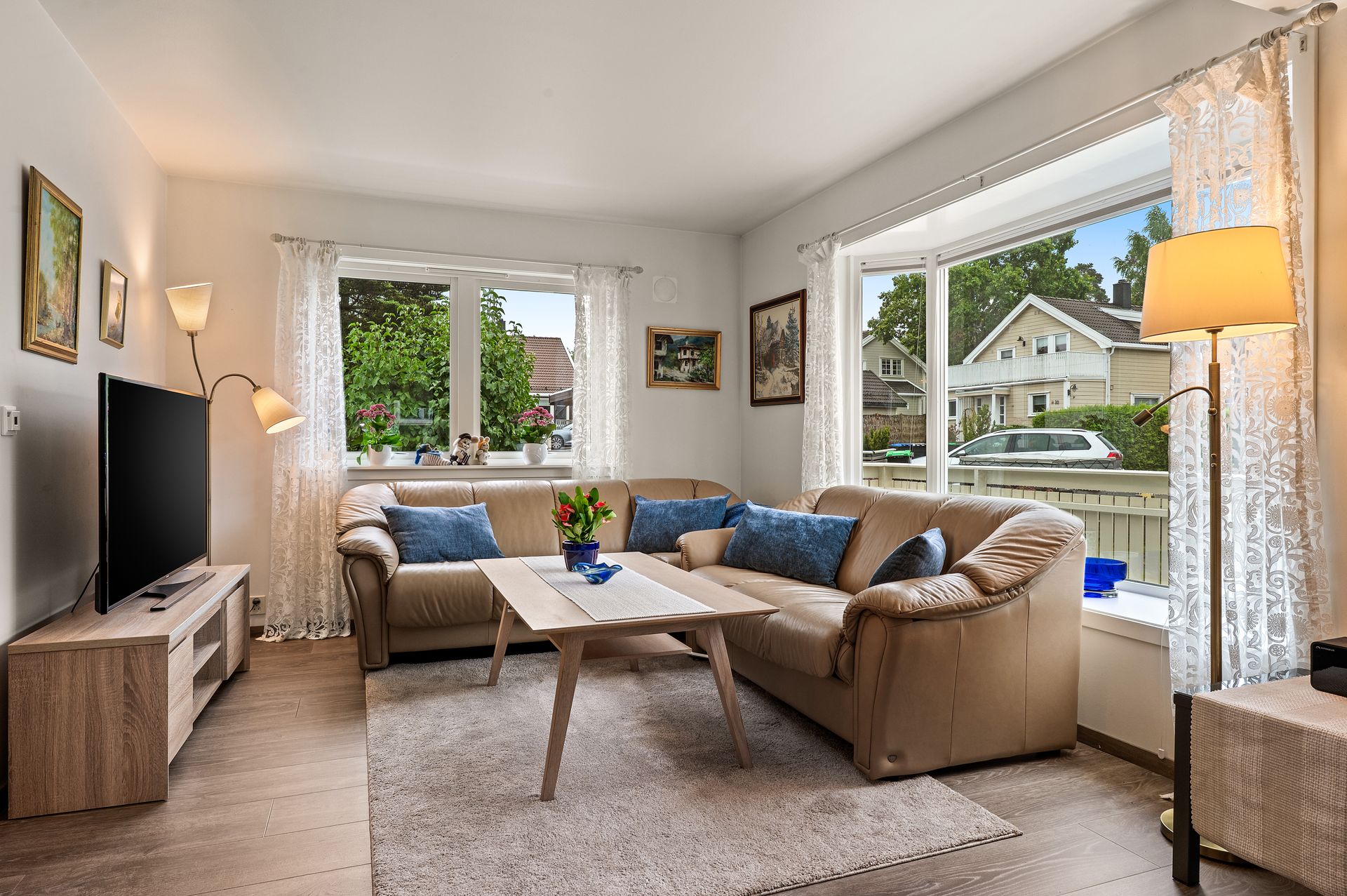 Stuen har plass til en romslig sofagruppe og får lys fra flere vindusflater.. Bilde nummer 2 av 3