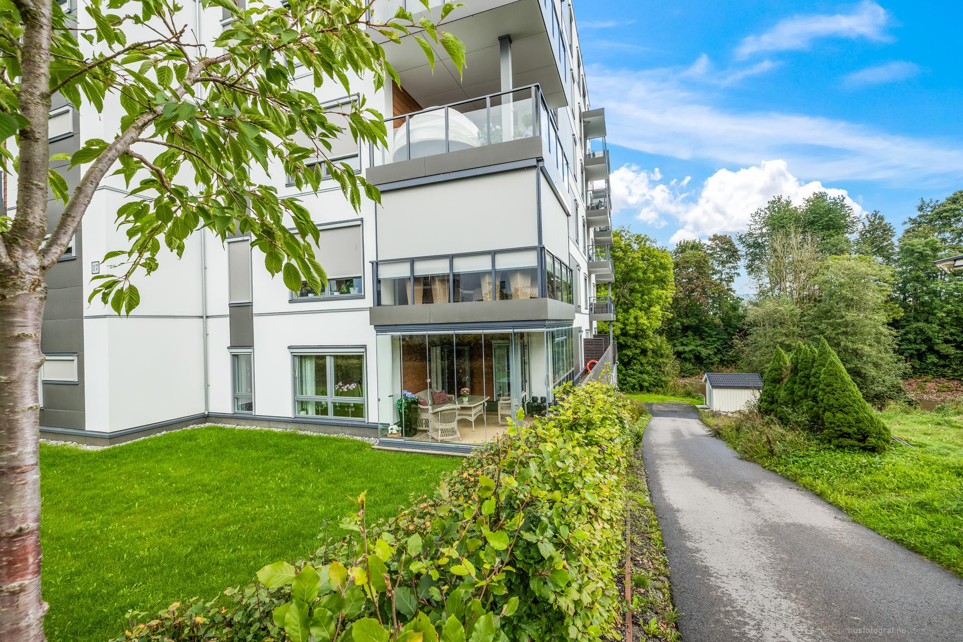 Det er gangstier, parkeringsplasser og grøntanlegg rundt leiligheten.. Bilde nummer 3 av 3