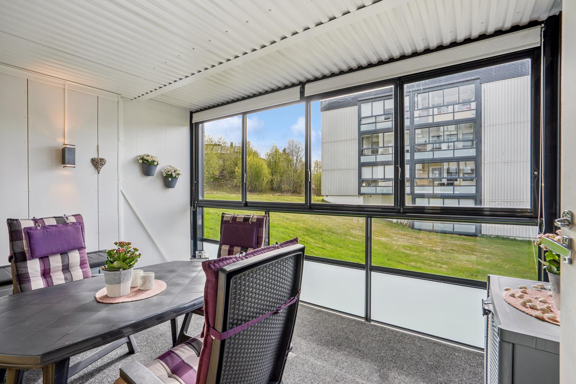 Den innglassede balkongen utvider stuen og gir et ekstra oppholdsrom store deler av året.. Bilde nummer 3 av 3