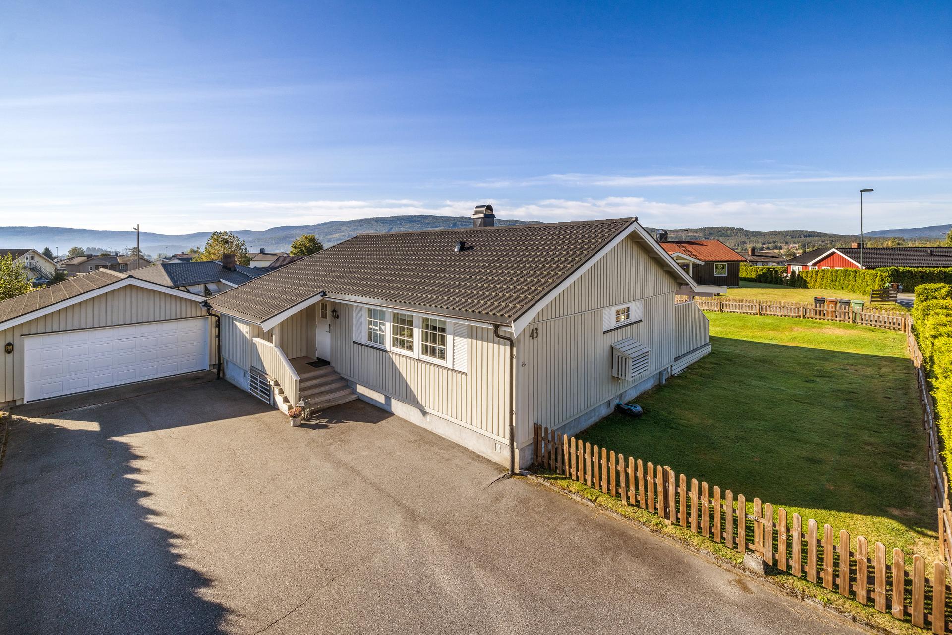 Frittstående enebolig på ett plan med flat tomt, stor sørvestvendt terrasse og frittstående dobbelgarasje.. Bilde nummer 2 av 3