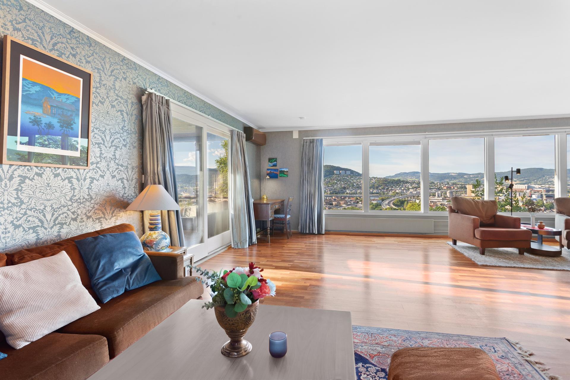 Stuen er et stort og sosialt rom med plass til både avslapning og sammenkomster. Store vindusflater med panoramautsikt over Drammen og fjorden.. Bilde nummer 3 av 3