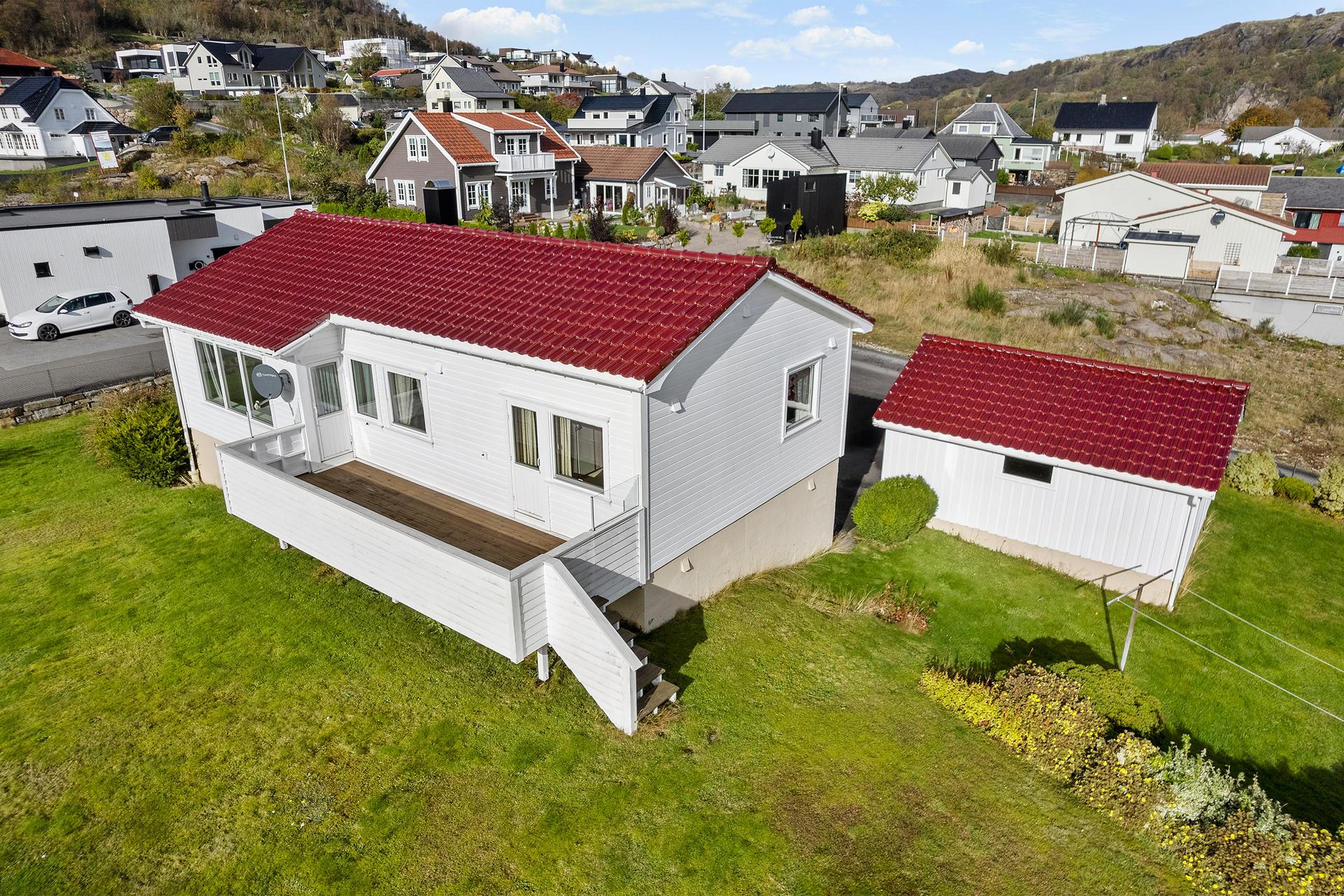 Boligen har terrasse ut fra stuen og stor hage med integrert garasje samt en frittliggende garasje.. Bilde nummer 3 av 3