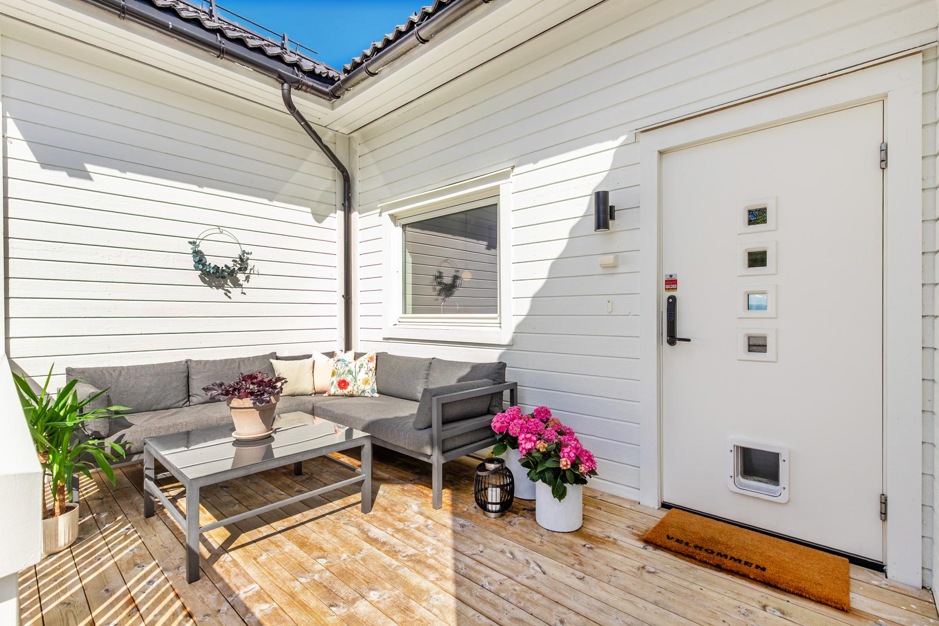 Hyggelig terrasse ved inngangspartiet skaper en innbydende velkomst.. Bilde nummer 3 av 3