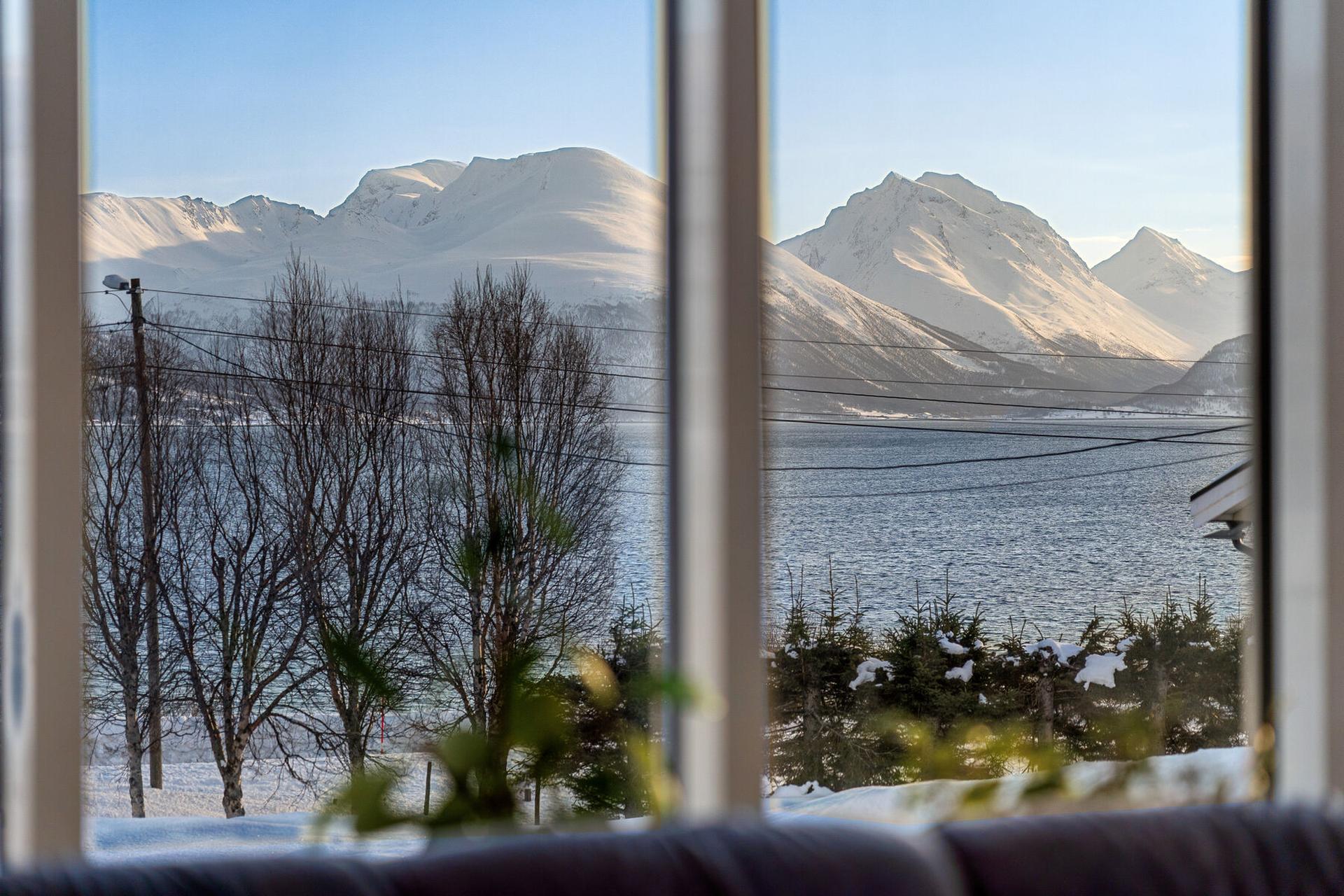 Utsikt mot snøkledde fjelltopper på Malangshalvøya.. Bilde nummer 1 av 3