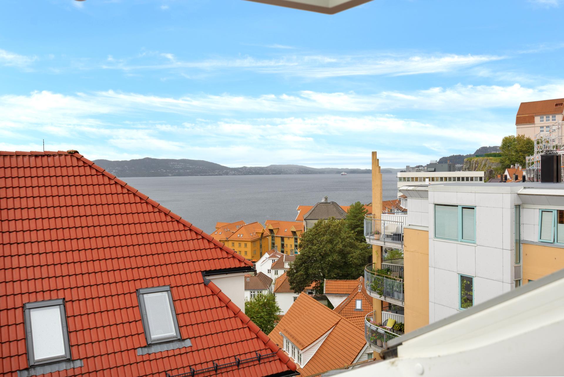 Fra vinduet er det åpen utsikt mot Byfjorden og omkringliggende byhustak.. Bilde nummer 1 av 3