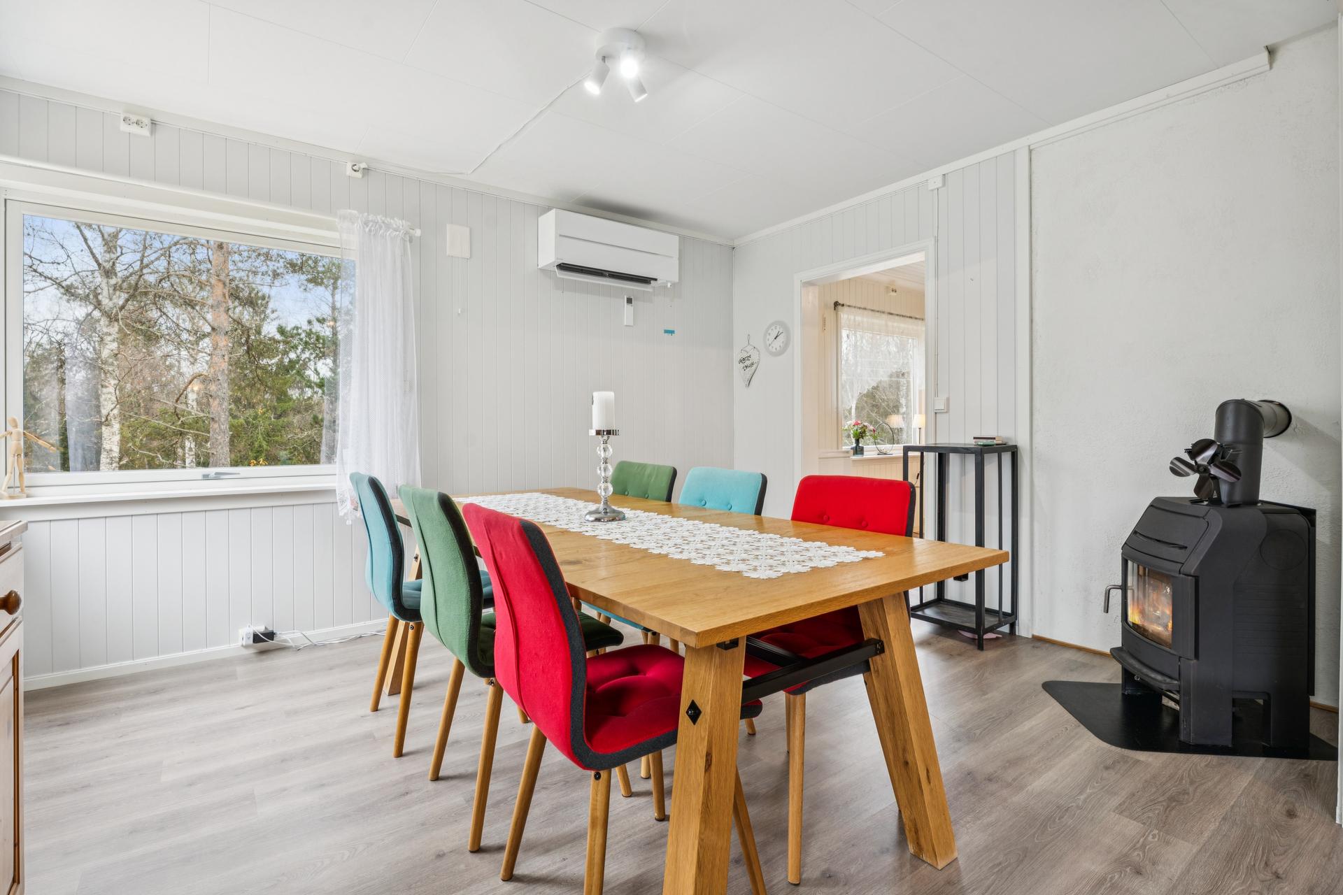 Stuen er utstyrt med peisovn og varmepumpe, og har god plass til spisebord.. Bilde nummer 3 av 3