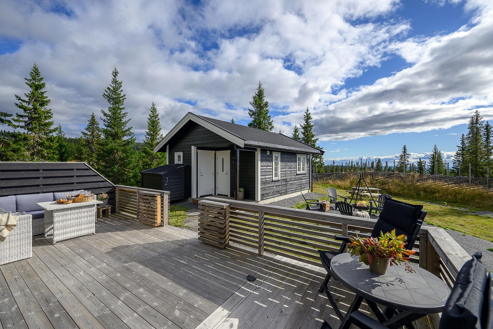 En stor og god, solrik terrasse er et perfekt sted å lande etter en dag på tur. Gode muligheter til å møblere. Vel tilrettelagt for å nyte utelivet i hytteveggen.. Bilde nummer 2 av 3
