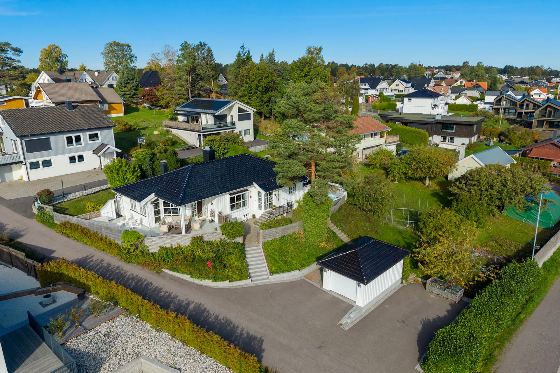 Eiendommen har asfaltert innkjørsel omrammet med ny belegningsstein/murer. Frittstående garasje oppført i 1982 og med fire biloppstillingsplasser.. Bilde nummer 2 av 3