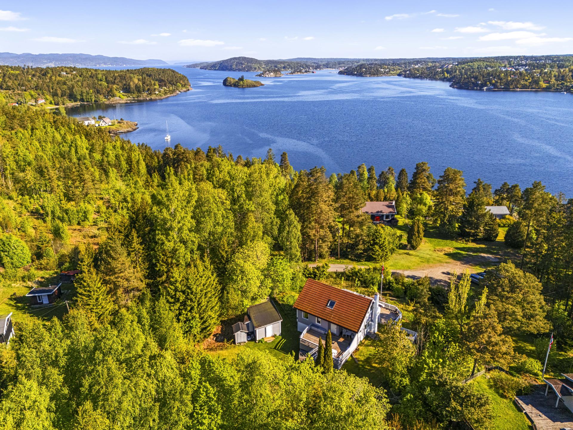 Boligen ligger fint plassert på tomten, med gode uteområder og utsikt.. Bilde nummer 3 av 3