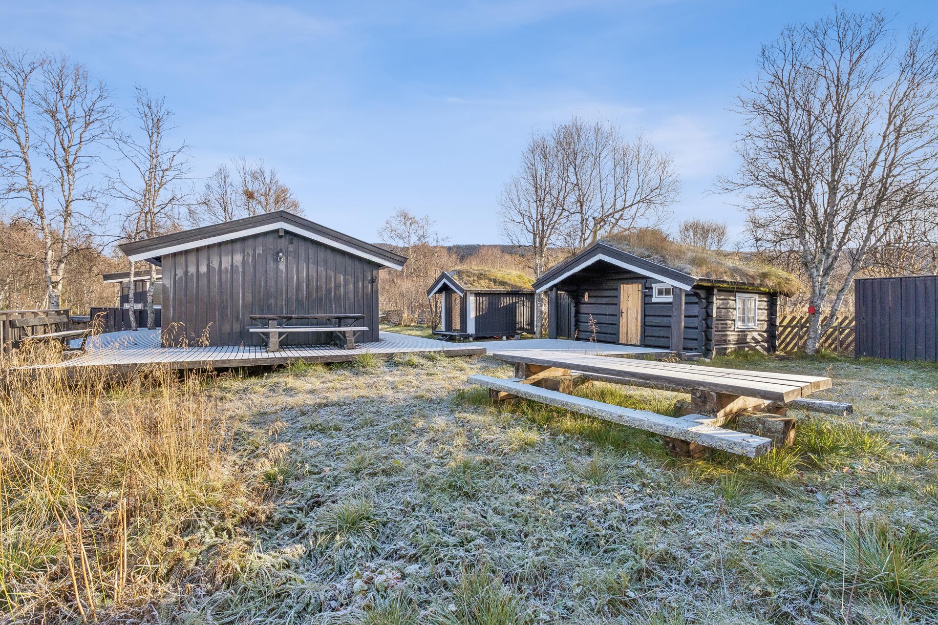 Innholdsrik fritidseiendom med hovedhytte, to anneks/uthus og uthus/bod samlet rundt et lunt tun. Bilde nummer 3 av 3