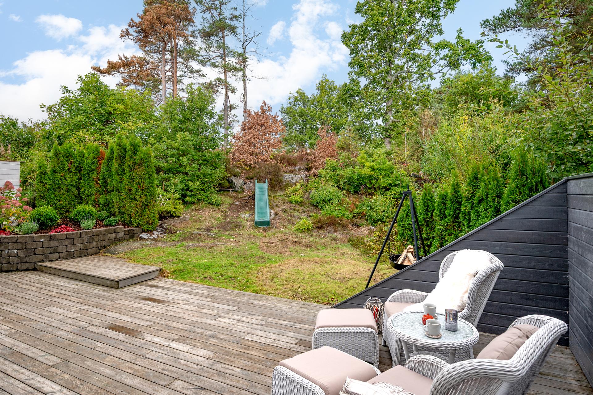 Uteplassen ligger usjenert til mot naturtomten og har plass til sofagruppe og bålpanne. Her er det kveldssol på sommeren.. Bilde nummer 3 av 3