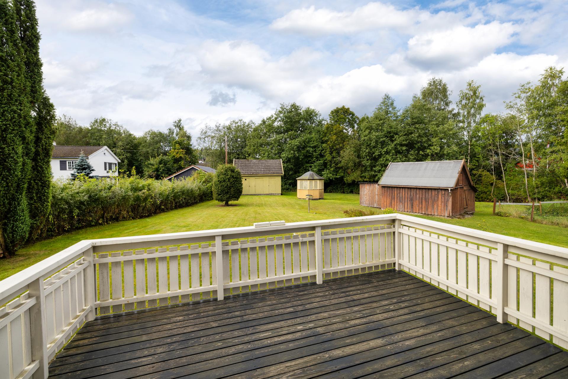 Stor, flat tomt med garasje, uthus og lysthus som gir rikelig med lagringsplass.. Bilde nummer 3 av 3