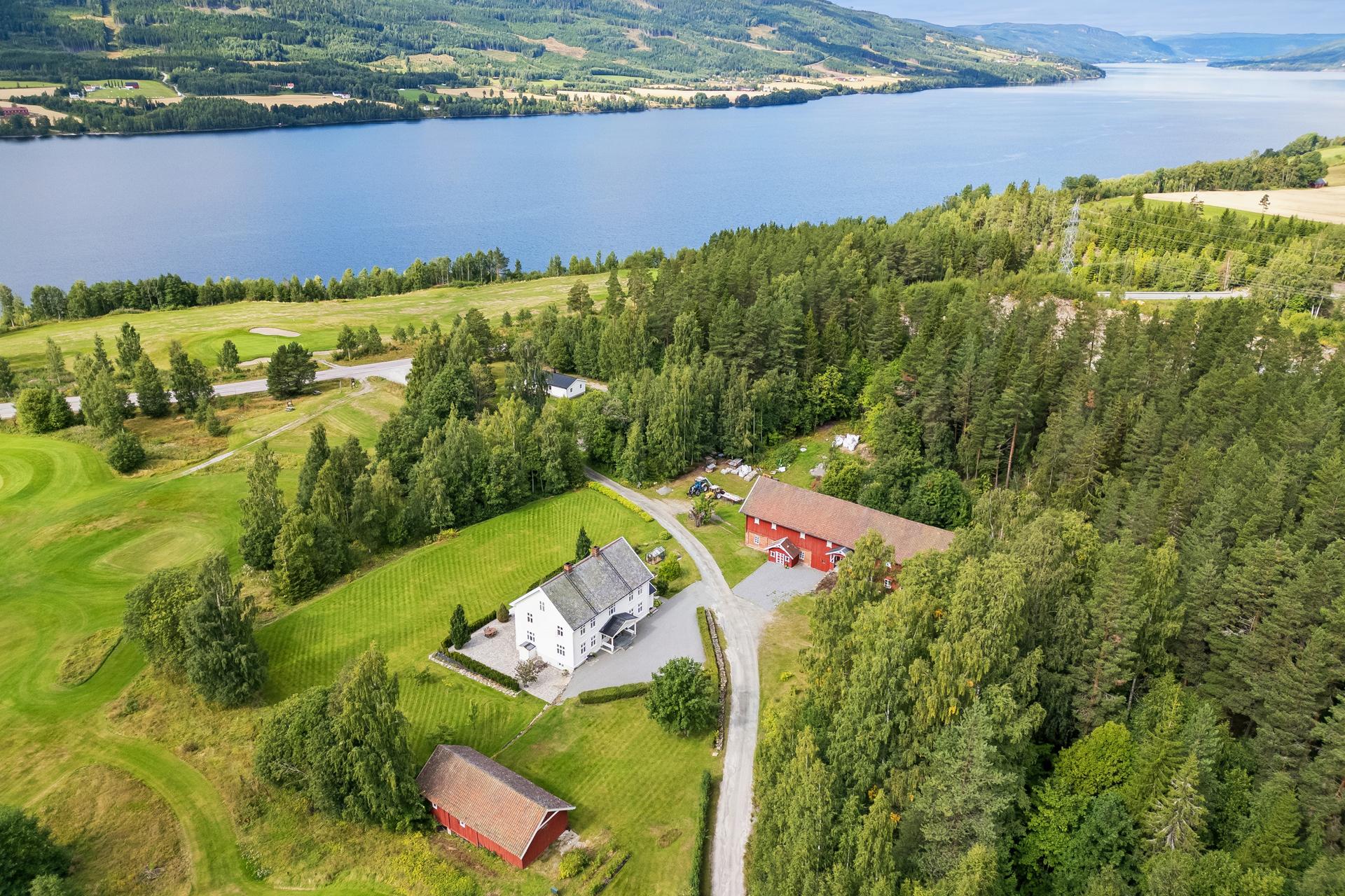 Oversiktsbilde av gårdstunet sett fra sør, og med Randsfjorden i bakgrunnen. Bilde nummer 2 av 3