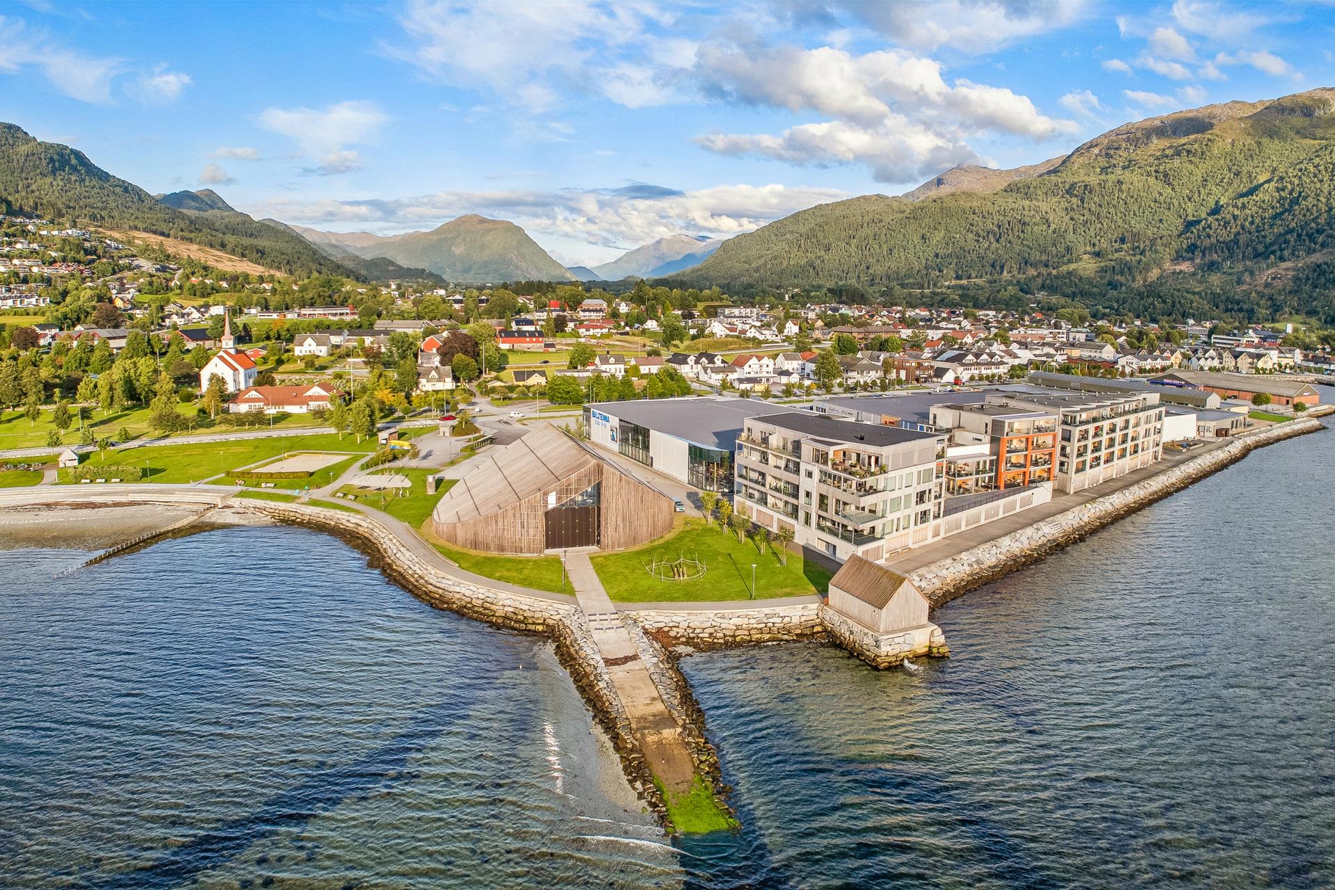 Leilegheita ligg omlag heilt i strandkanten, rett ved Sagaparken, med gjennomgang via parkeringskjeller til Alti Nordfjord med butikkar, apotek og kafé.. Bilde nummer 3 av 3