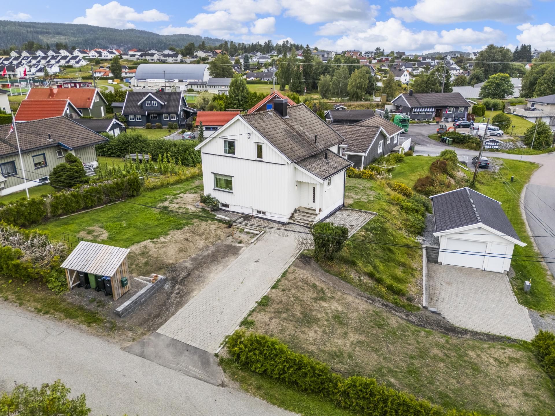 Eiendommen har en romslig tomt og garasje fra 2017 med elektrisk port og opplegg for elbillader. Her er det utført viktige oppgraderinger, bl.a. drenering og nye vann-/avløpsrør.. Bilde nummer 3 av 3