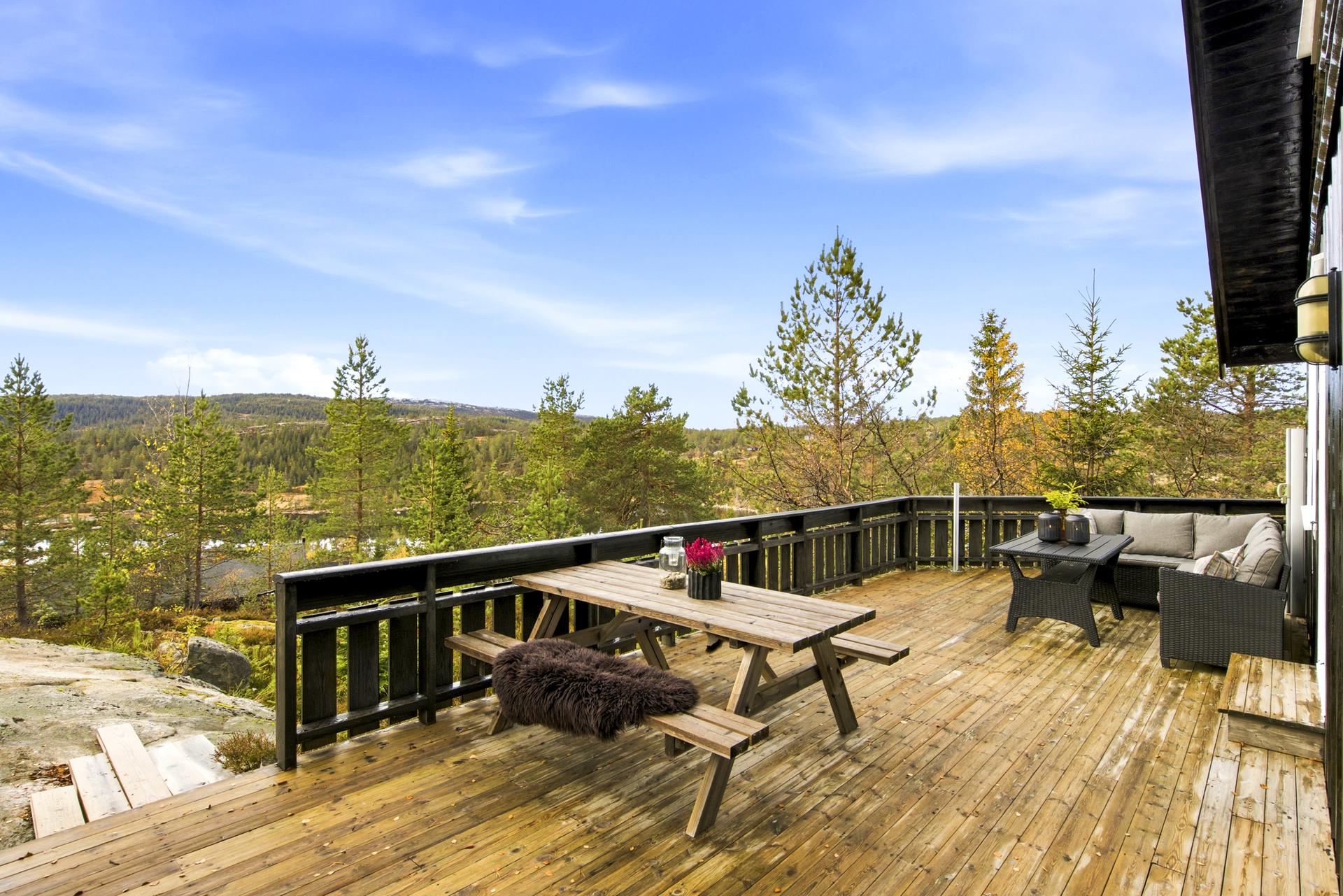 Terrassedekket strekker seg rundt hyttehjørnet og gir gode oppholdsplasser.. Bilde nummer 2 av 3