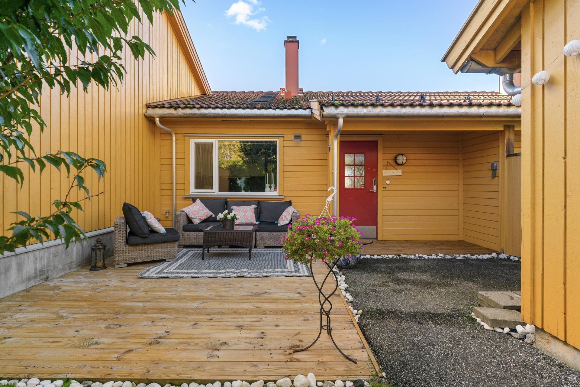 Ved inngangspartiet er det etablert en markterrasse i treverk med plass til sittegruppe.. Bilde nummer 3 av 3